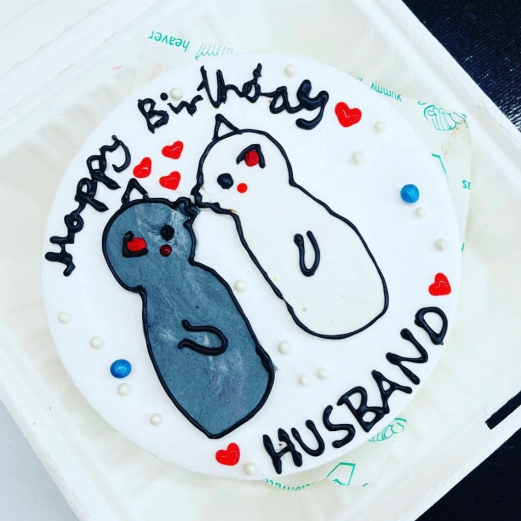 A beautifully decorated cake with a couple kissing, inscribed with "Happy Birthday Husband."