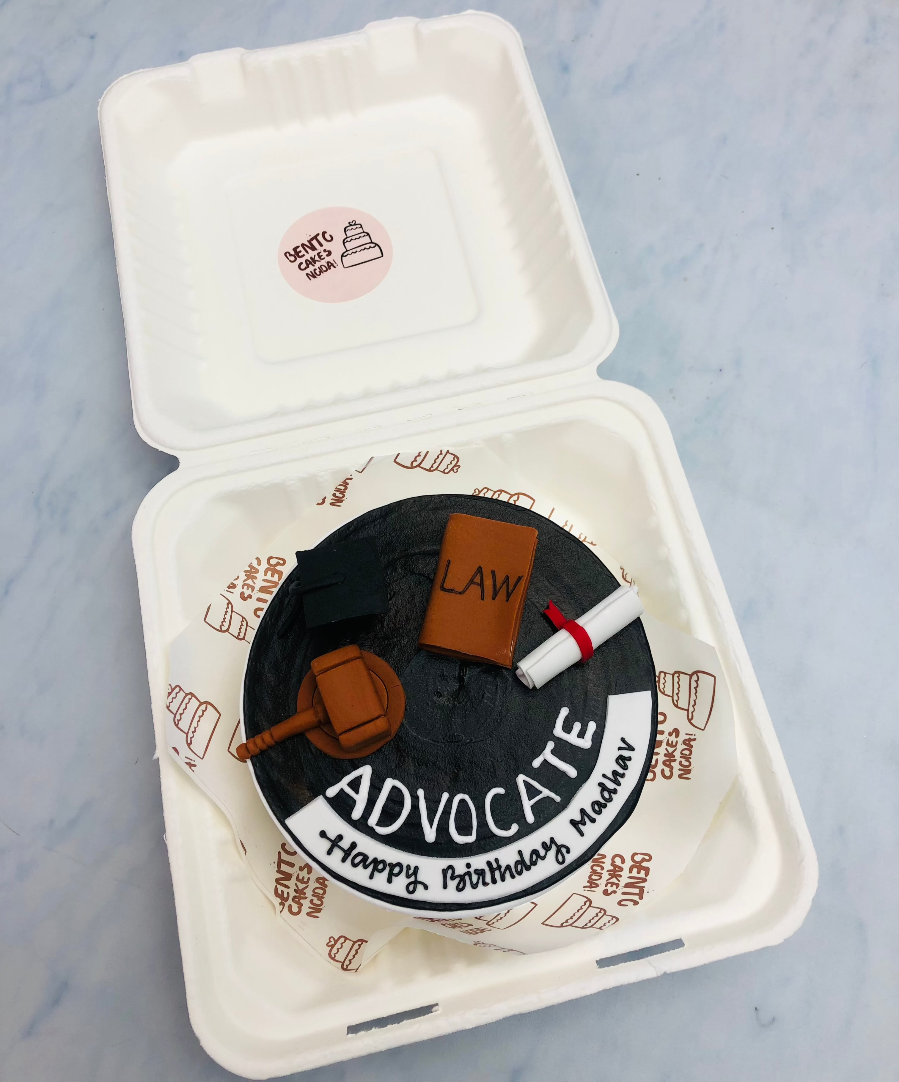 A black bento cake is designed with fondant items for a lawyers birthday.