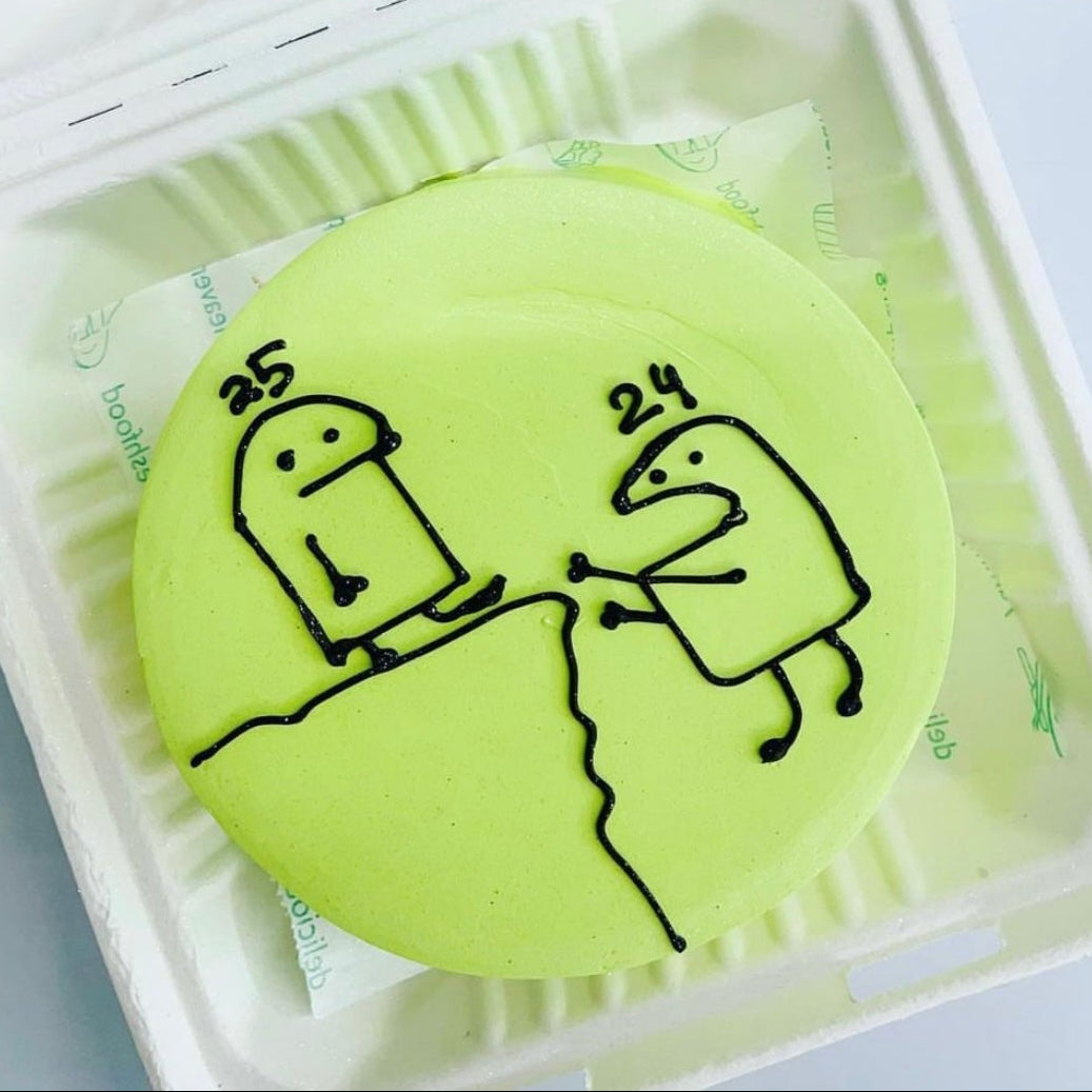 A green cake showcasing a cute drawing of two people getting aged, bringing a fun and artistic flair to your meal.