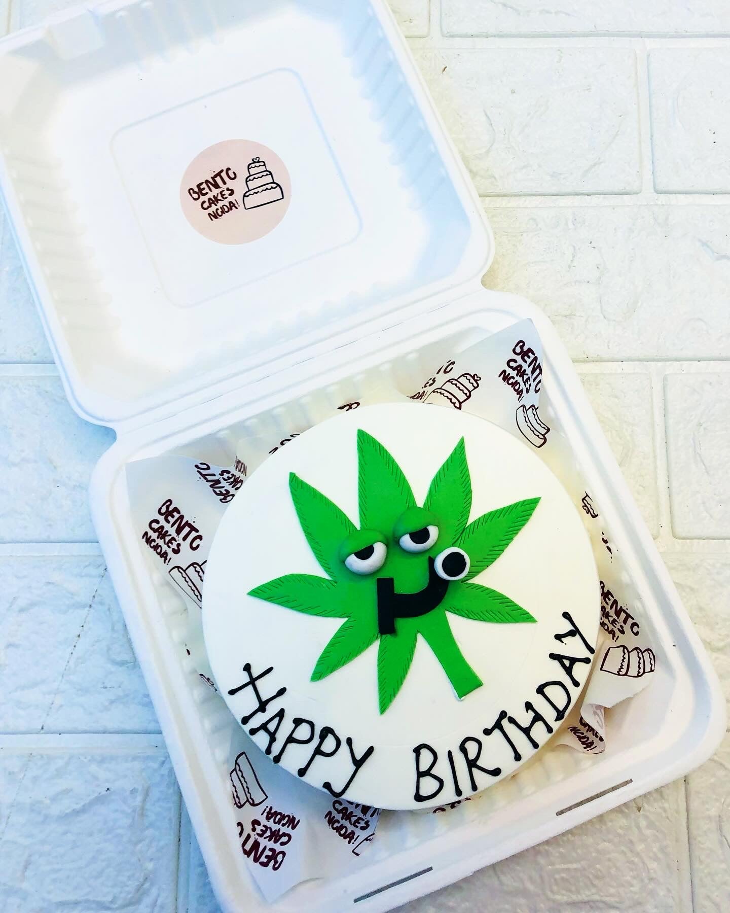 A weed leaf design on a white bento cake for birthday.