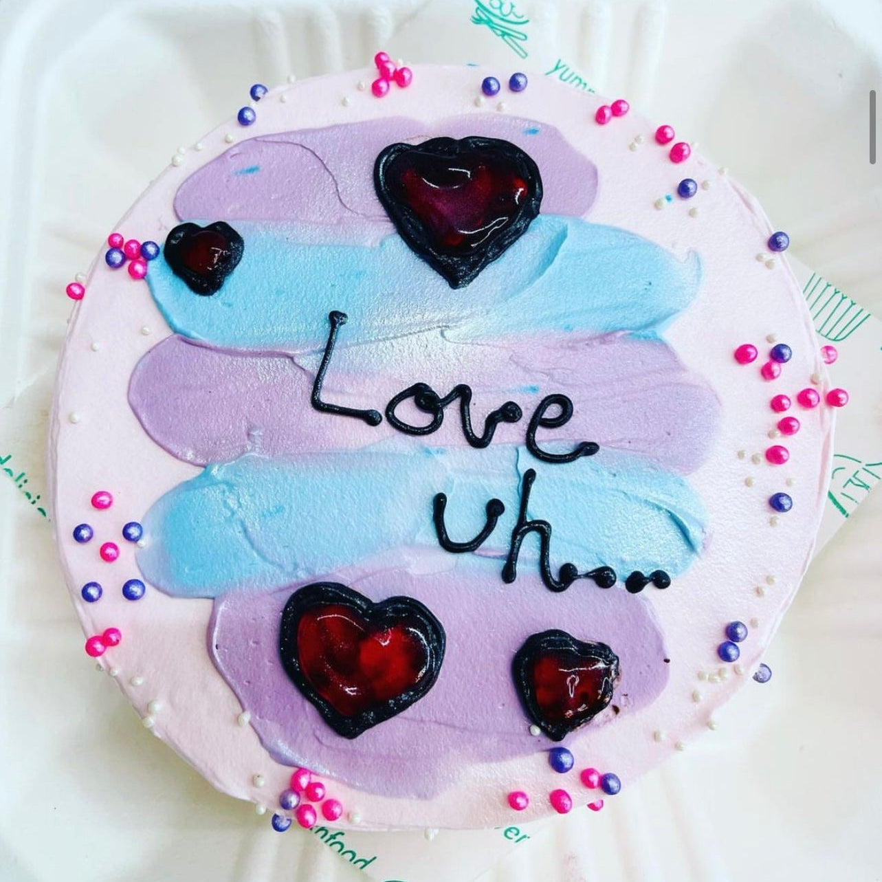 A cake decorated with the words "love u" elegantly written on its surface, showcasing a heartfelt message.