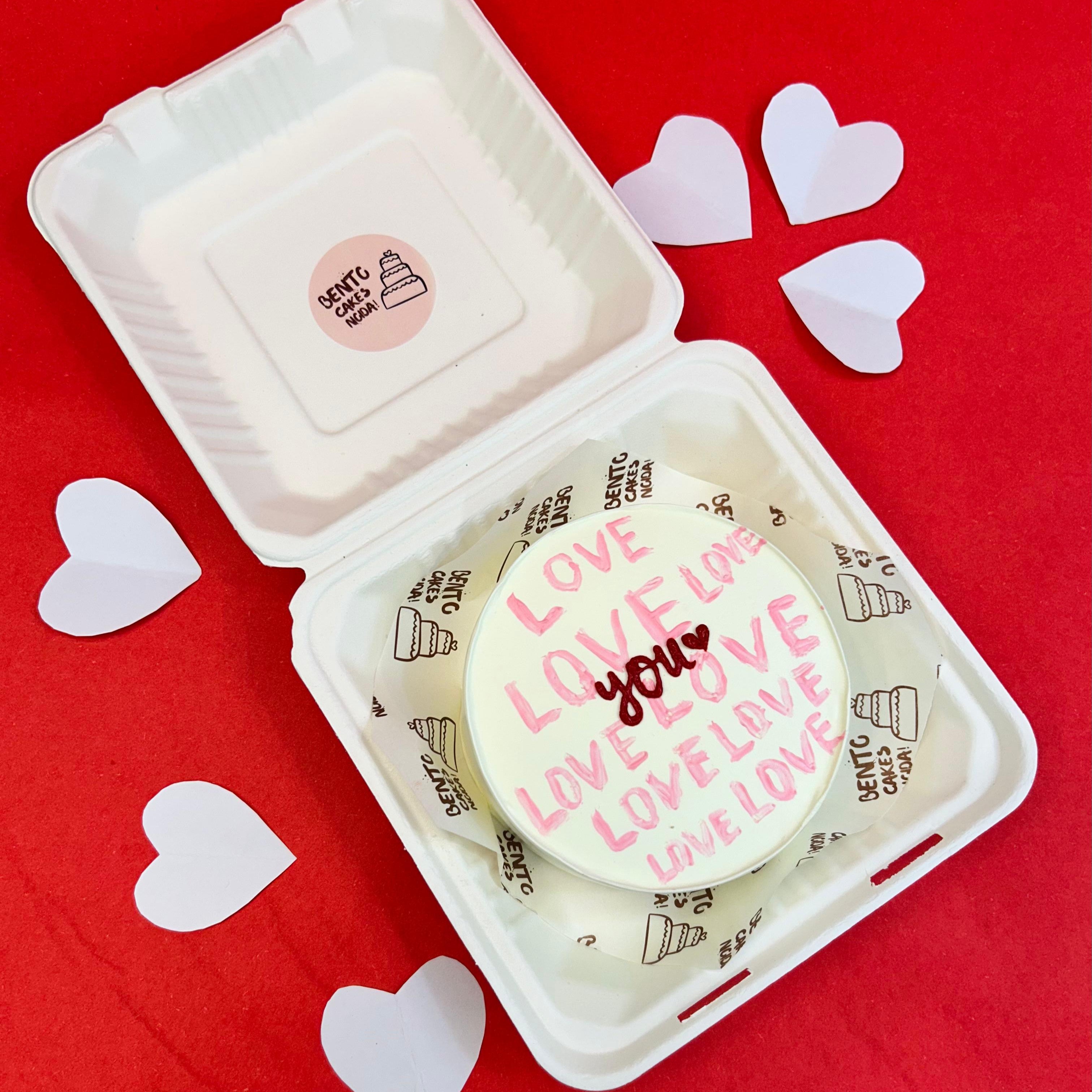 A white box featuring a cake that displays the words "Love You" in a charming design.