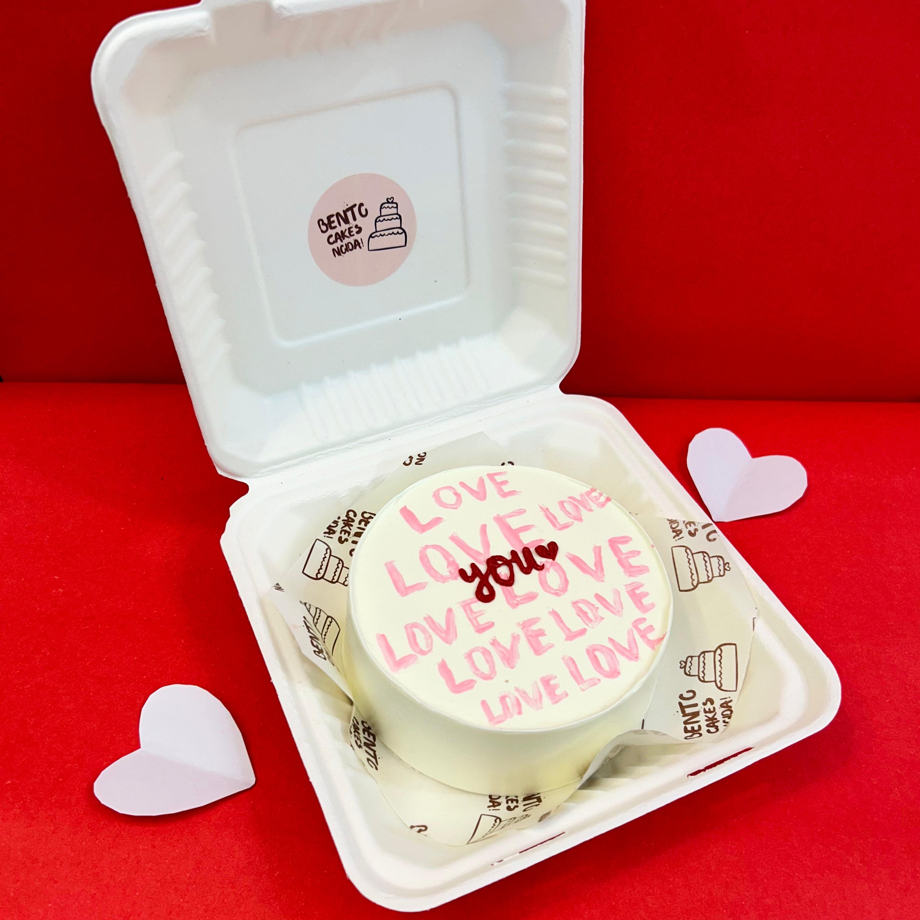 A white box featuring a cake that displays the words "Love You" in a charming design with side view.