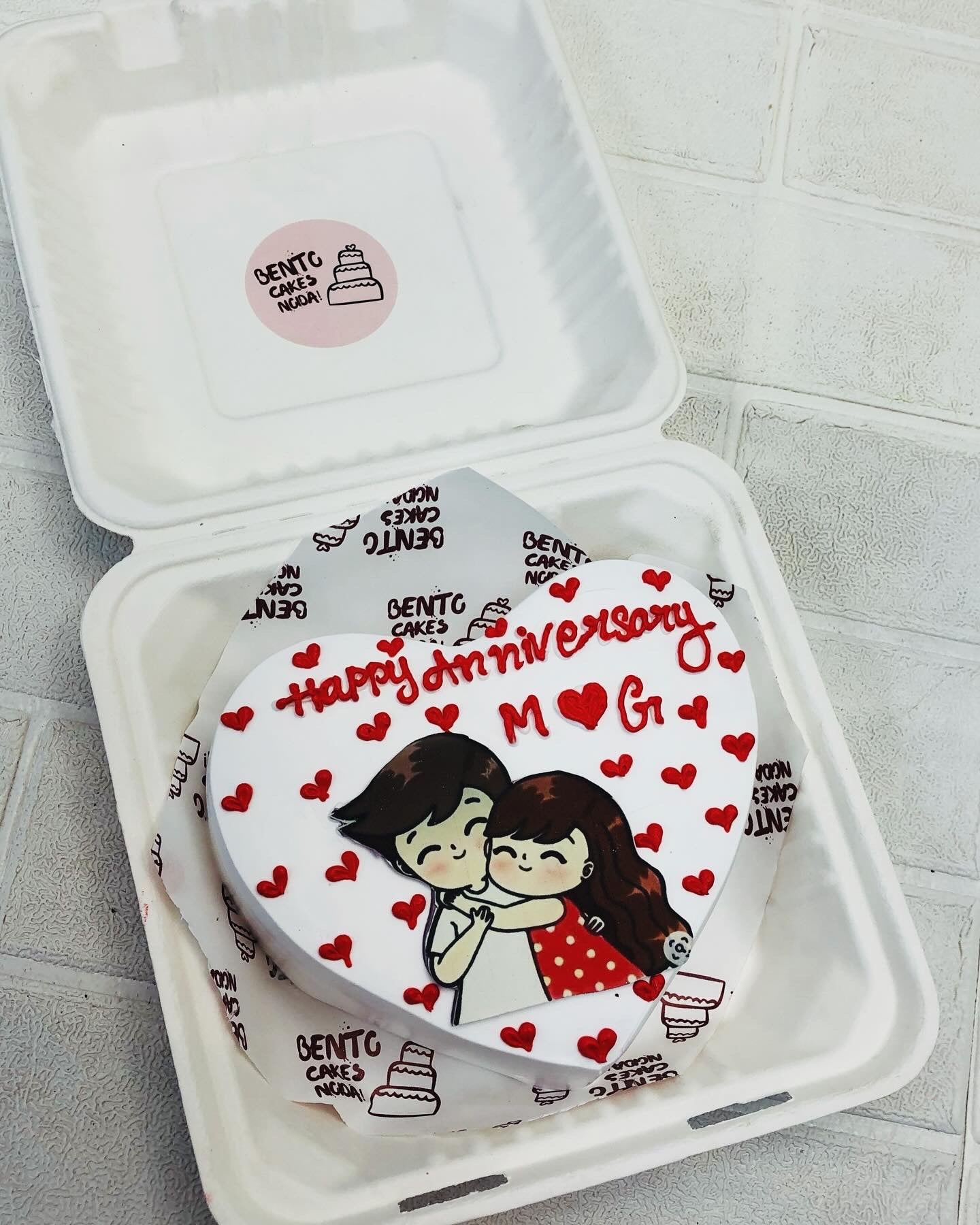 A white heart sape cake with higging couple print and fll with hearts designs.