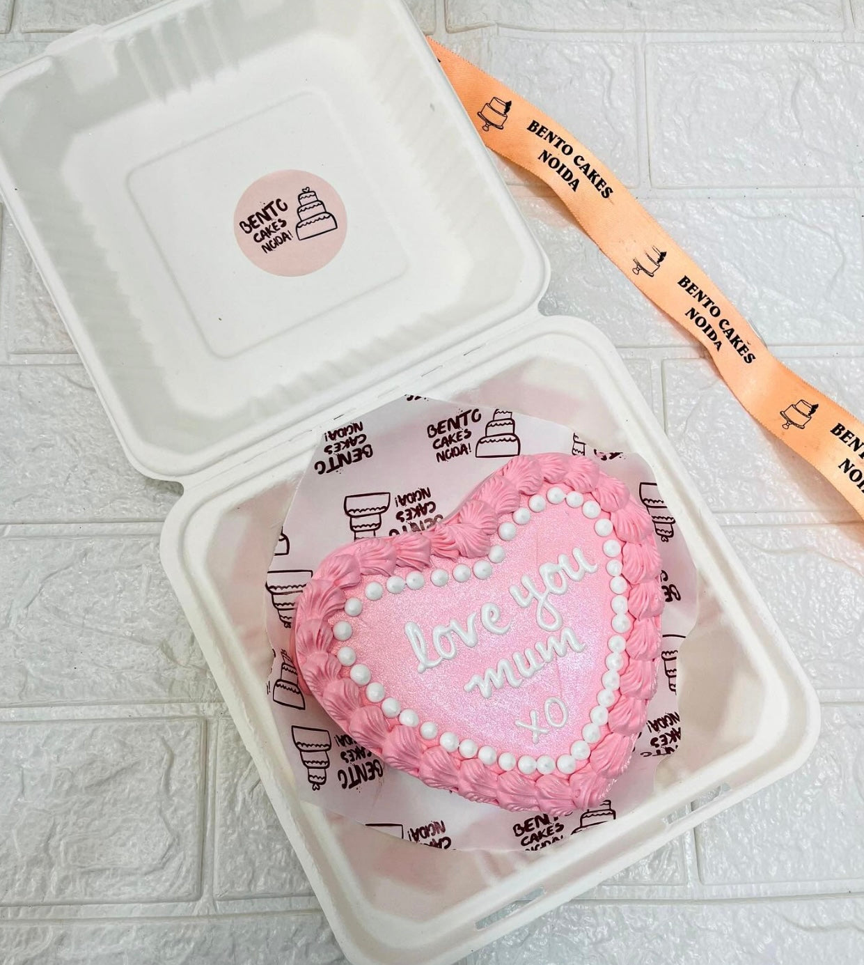 A light pink bento cake in heart shape and designed with pink florals for love you mum xo.