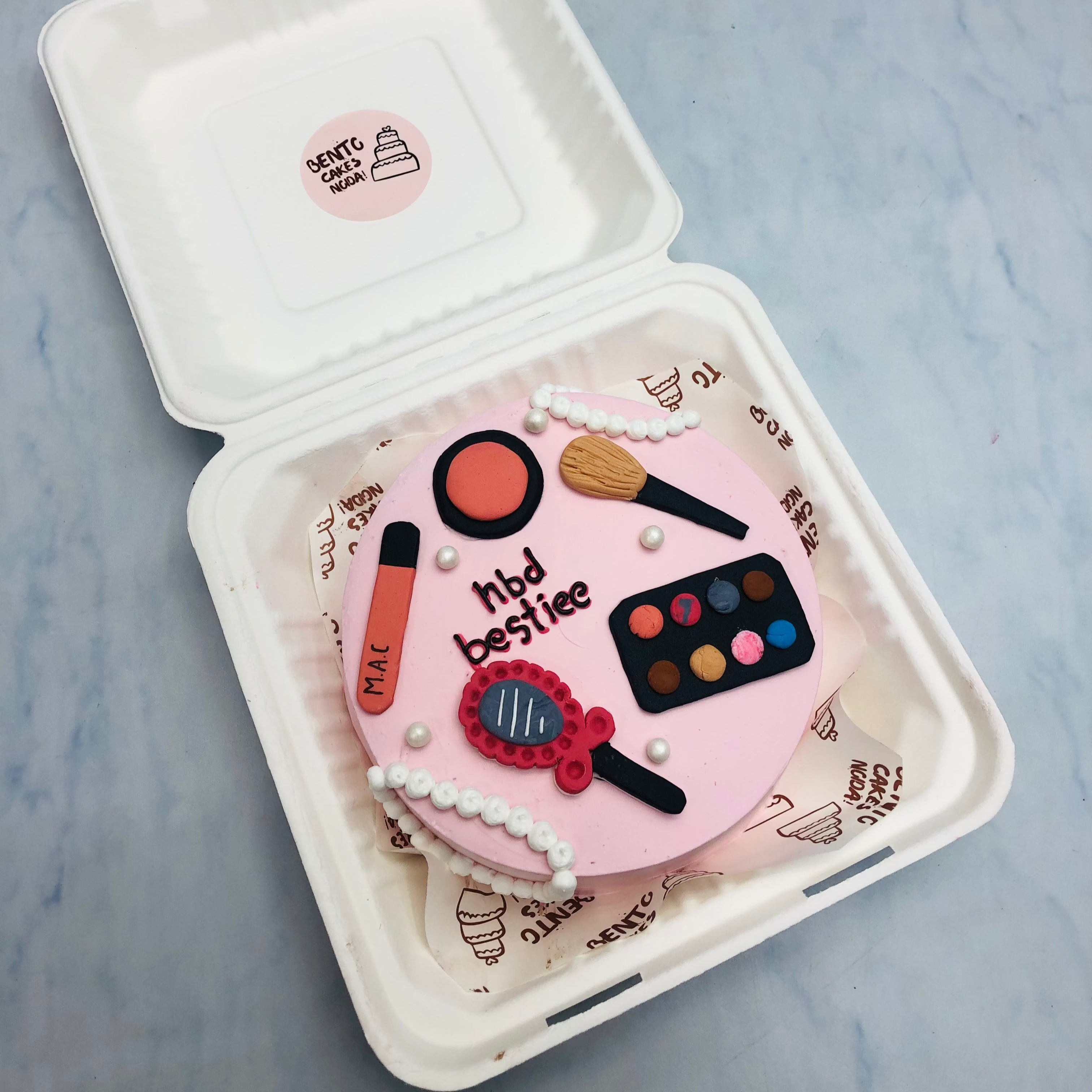 A Makepu theme fondant articles cake in light pink color.