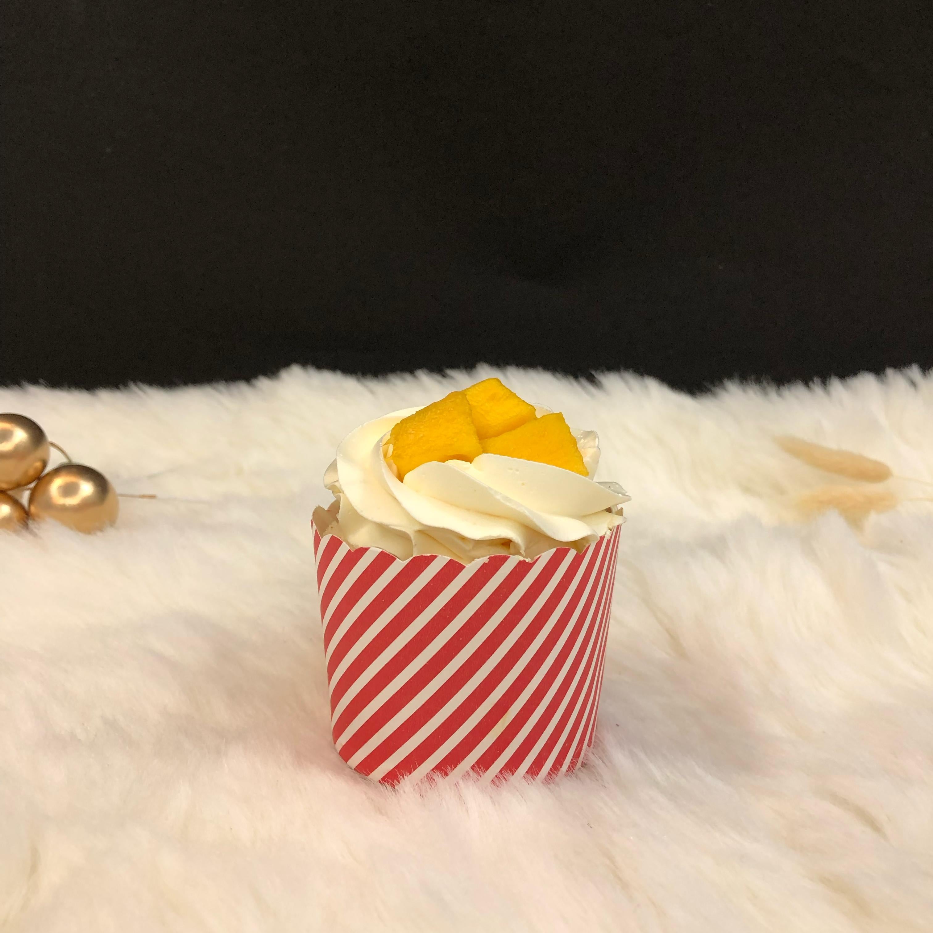 A cup filled with mango flavour and mango slices.