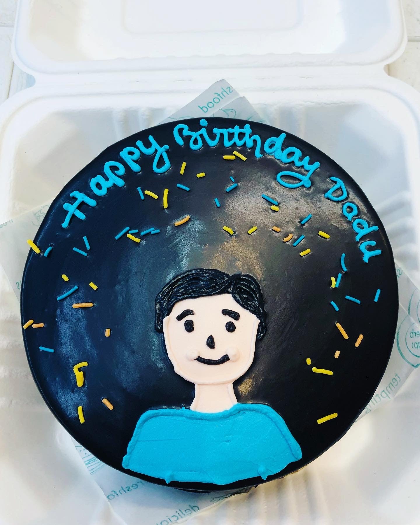 A delightful birthday cake showcasing a cartoon face, surrounded by colorful frosting and joyful decorations.