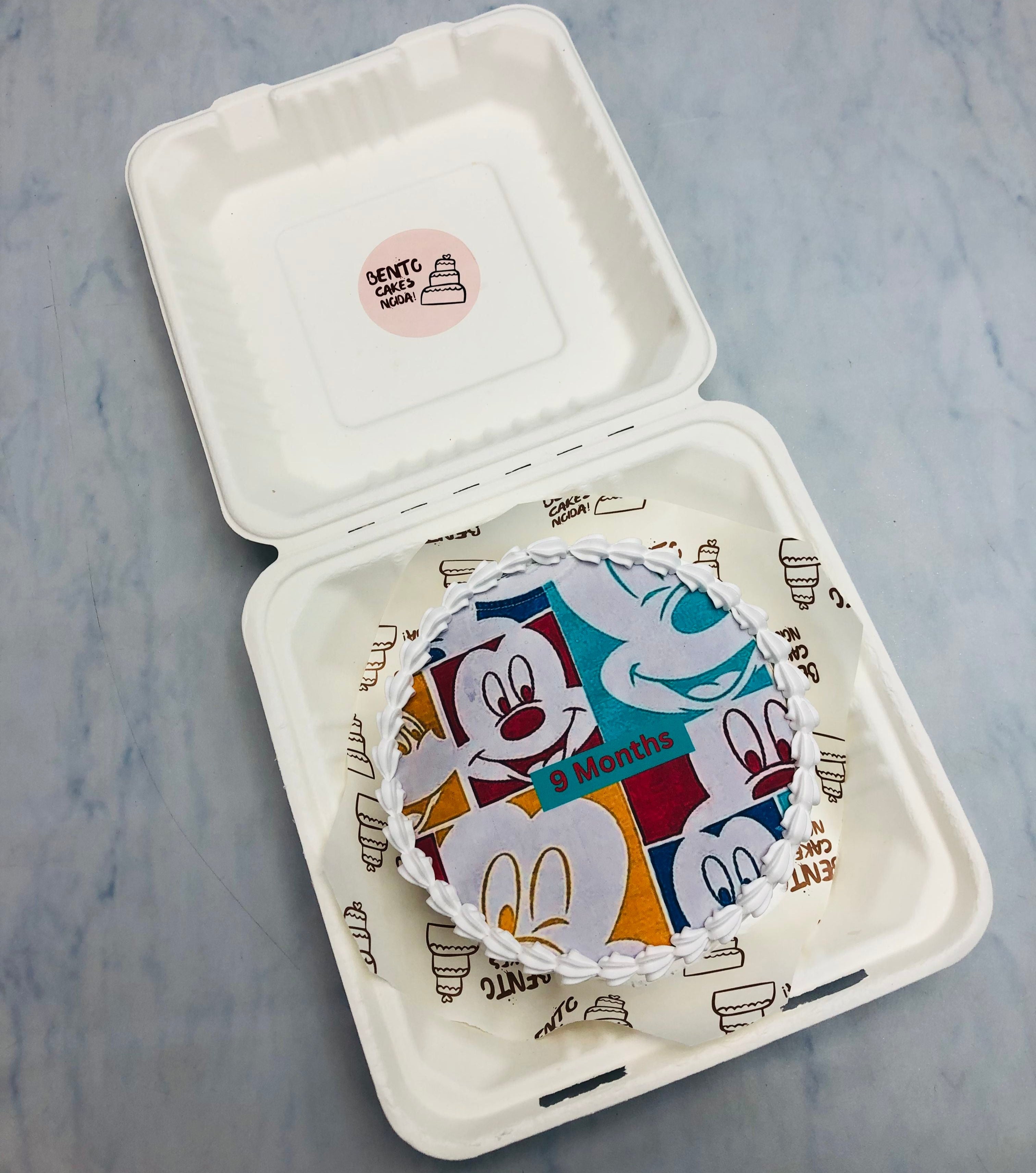 A micky mouse cartoon print on fire paper, celebrating 9 months of baby.