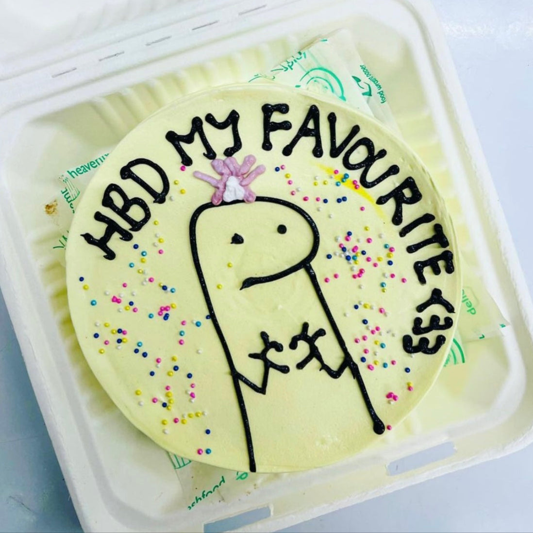 A colorful cake featuring a playful Mimi drawing on top, perfect for a fun celebration or birthday party.