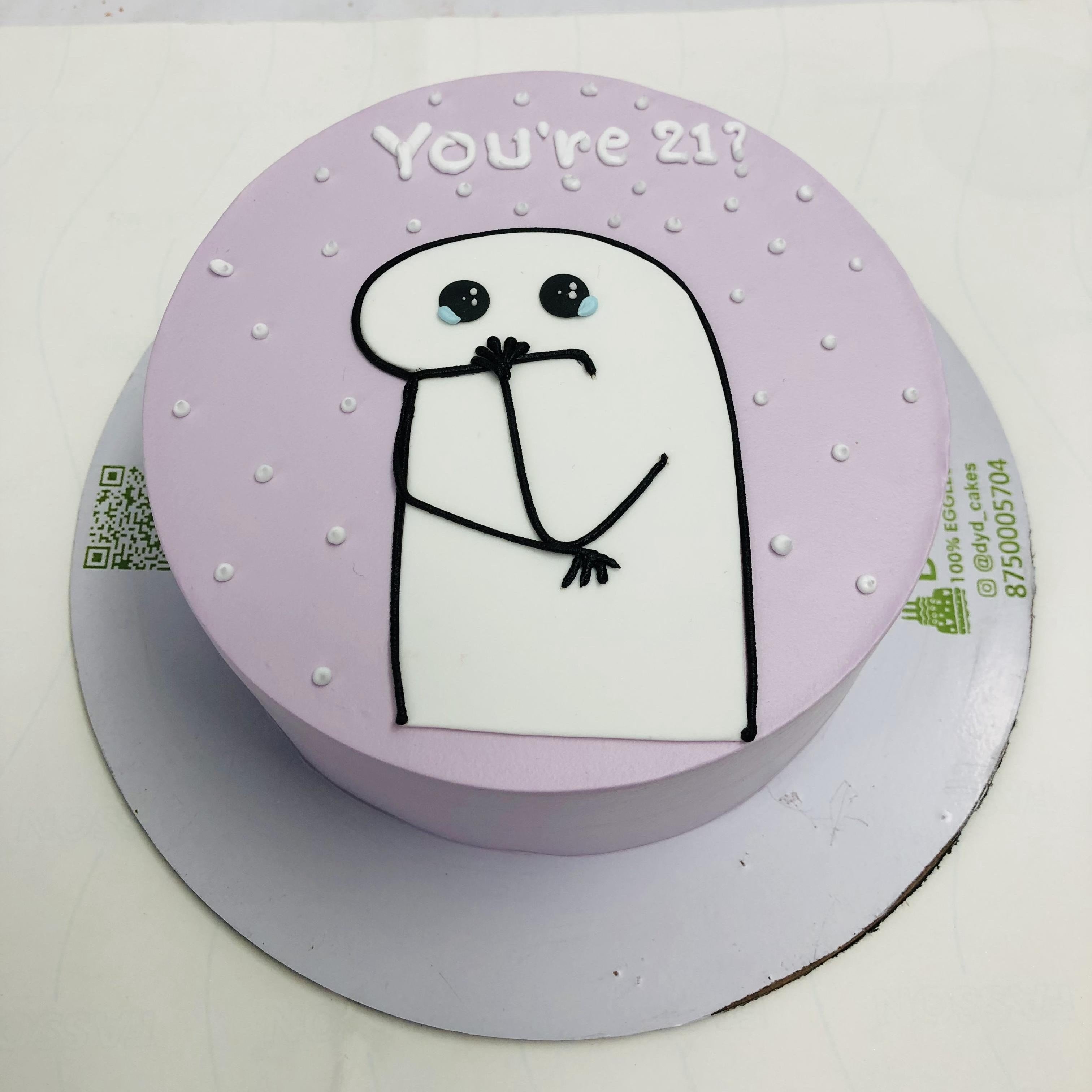 A light purple cake is decorated with a mimi cartoon character and a text "You're 21?" written on it.