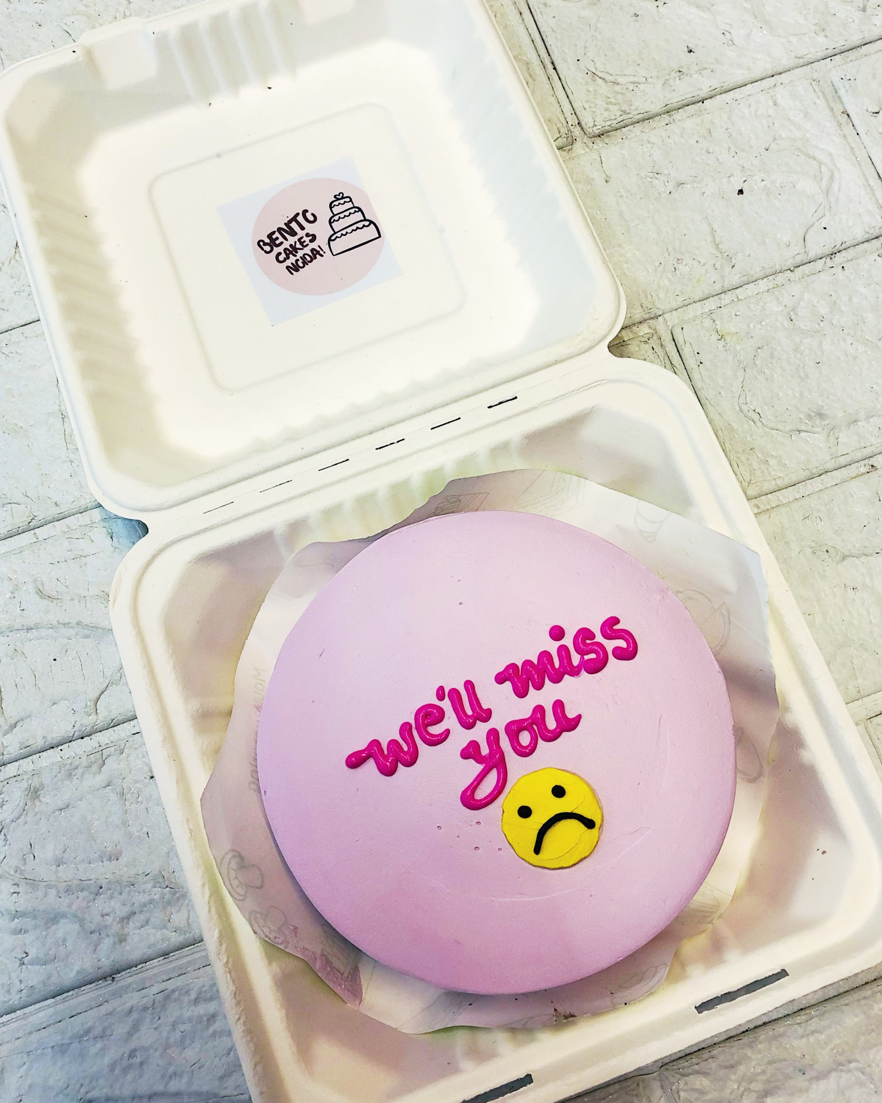 A light pink bento cake is designed for farewell with a sad emoji and missing text.