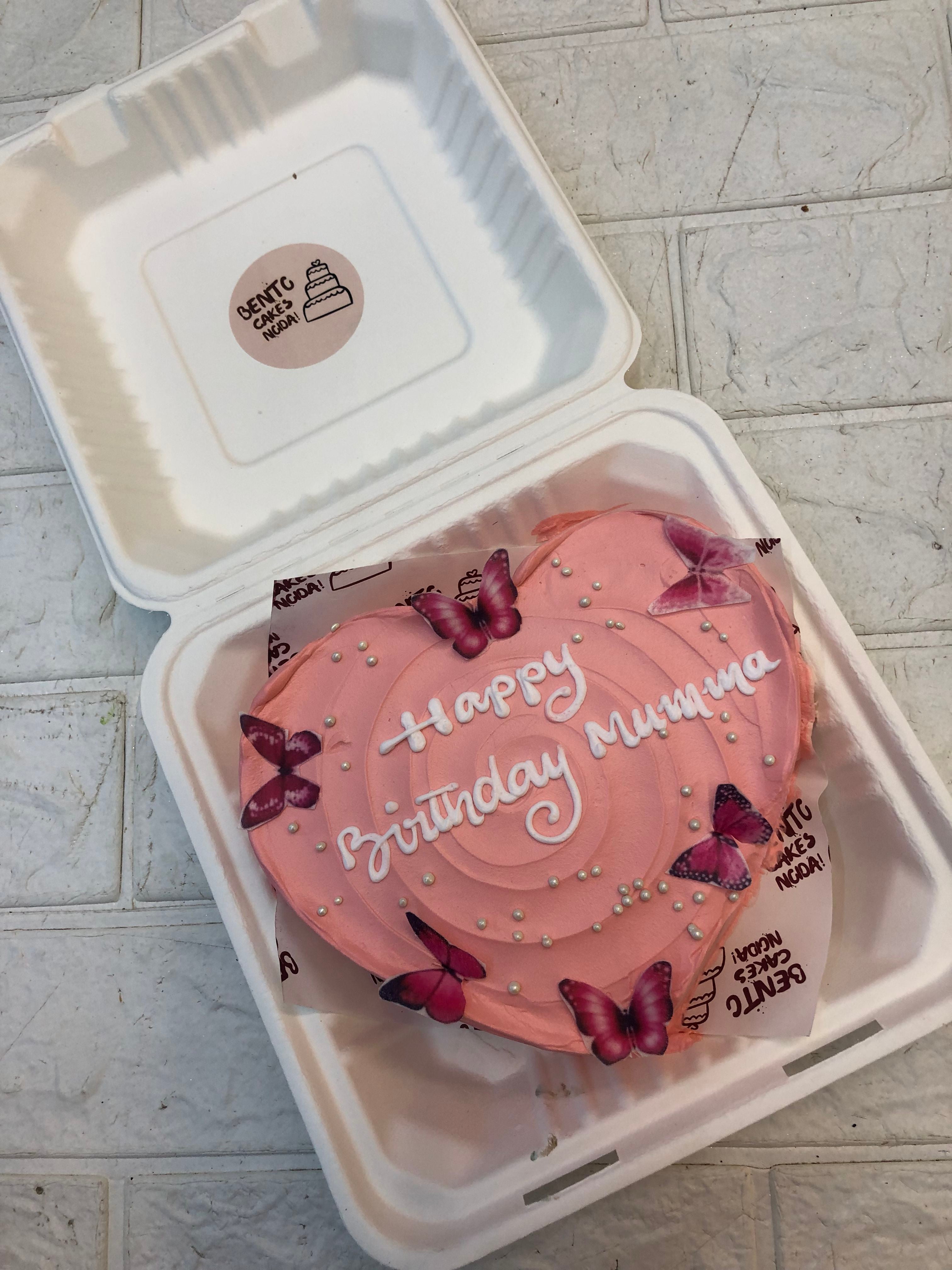 A Birthday Theme Heart Bento Cake with pink butterflies on it and an "Happy Birthday Mumma" written with white icing on it.