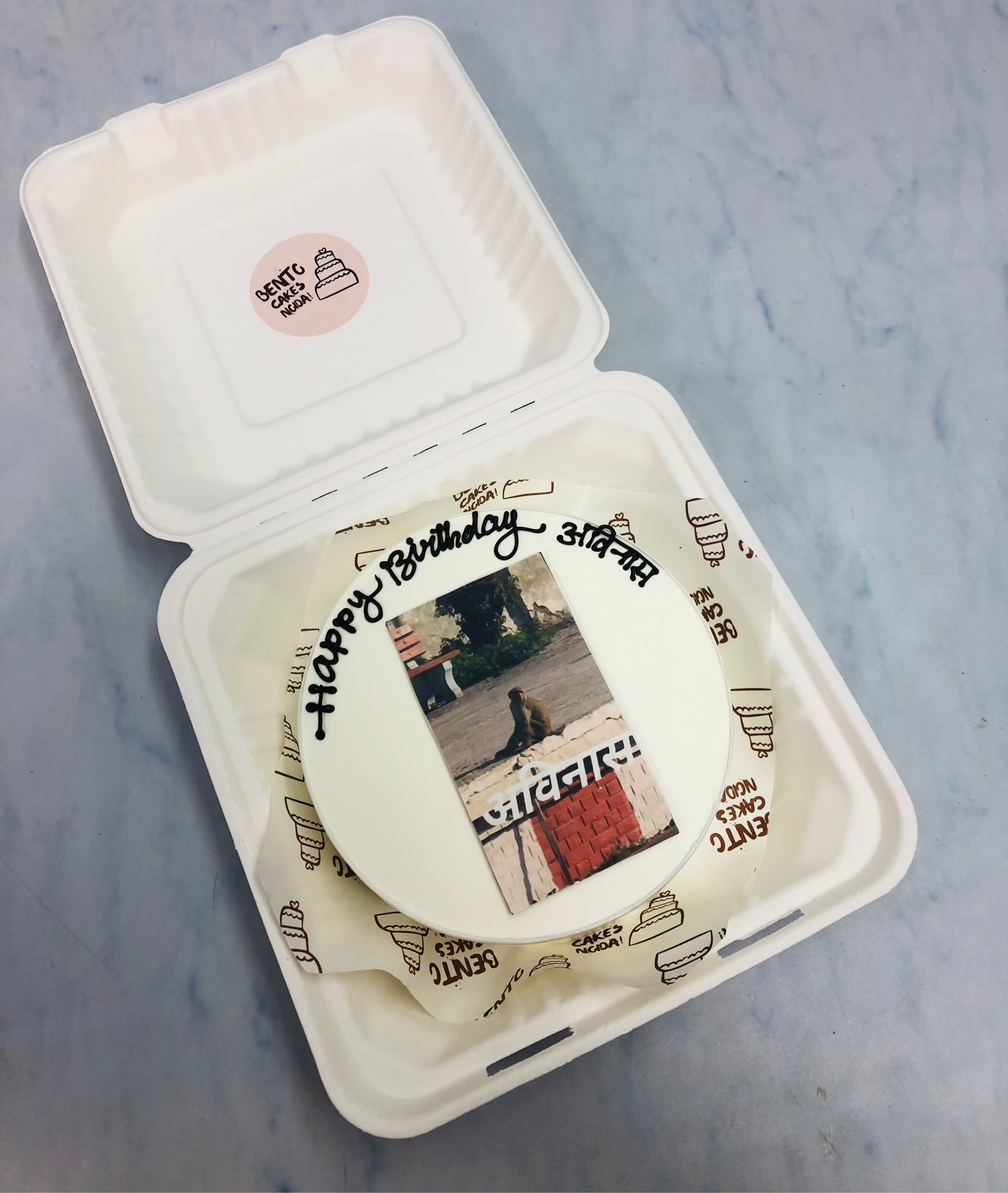 A white bento cake having a monkey birthday celebration picture.