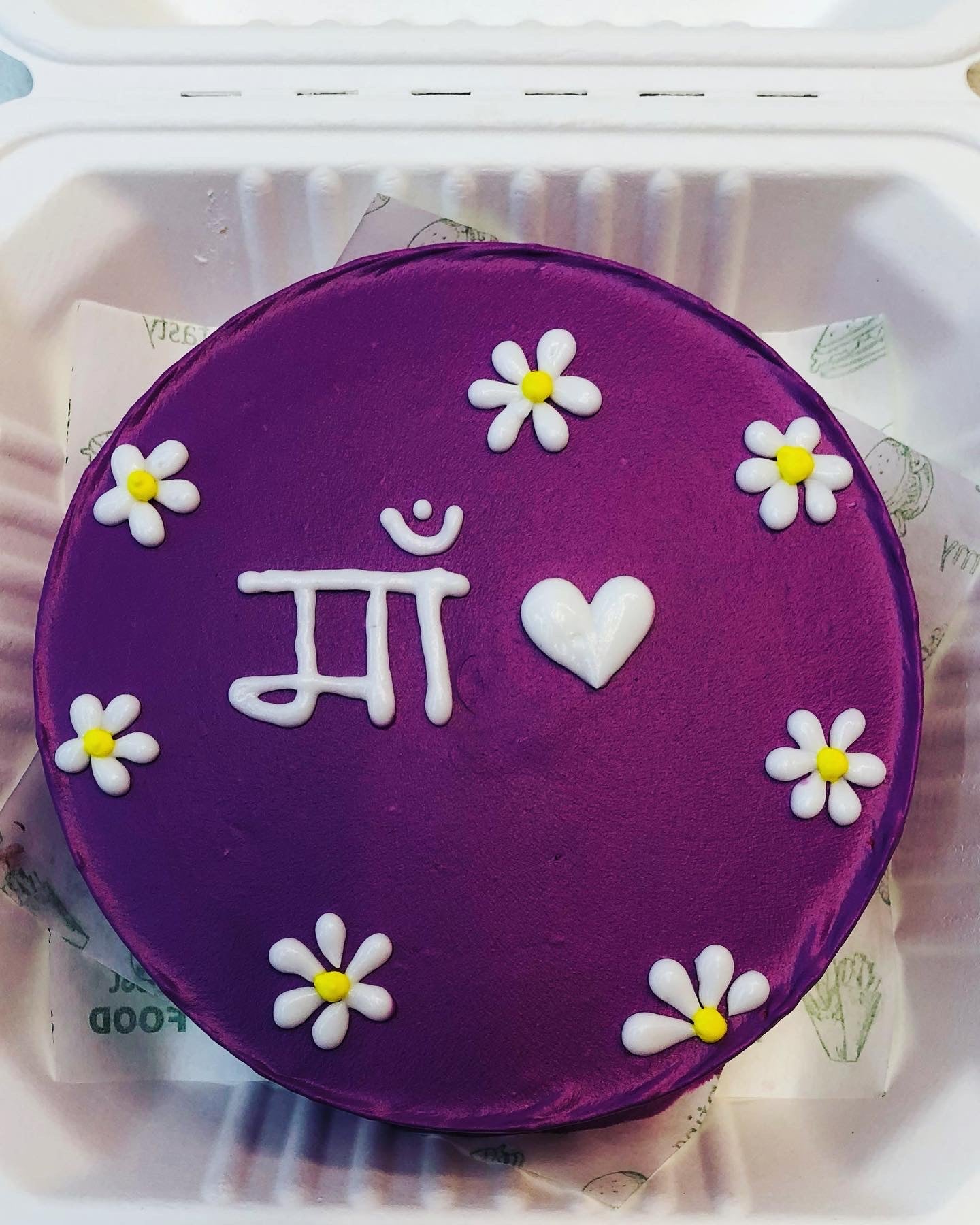 A delightful purple cake adorned with the word "love" elegantly written on top, perfect for any celebration.