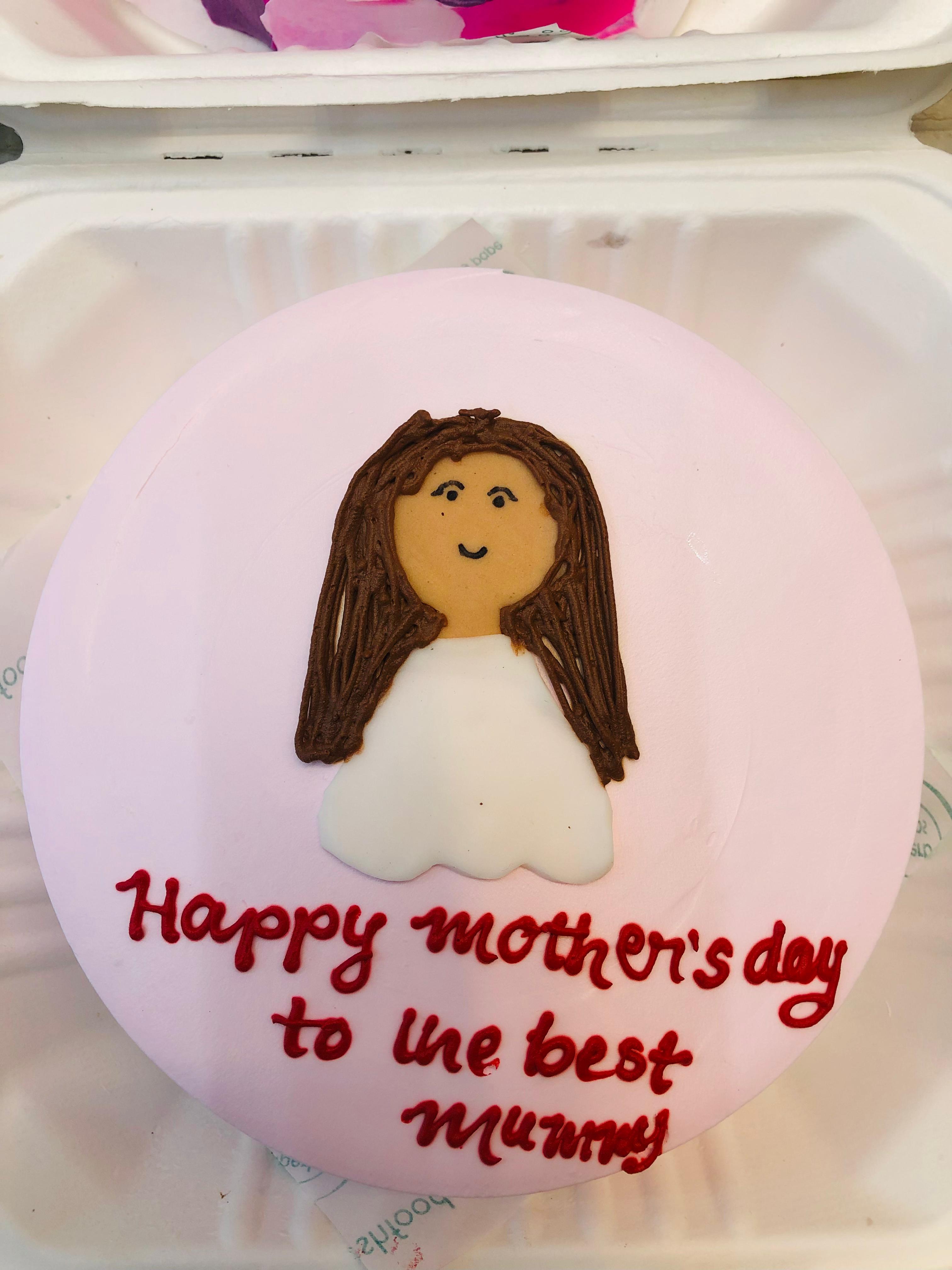 A light pink cake with a mother character made with fondanr and a beautiful text written on it.