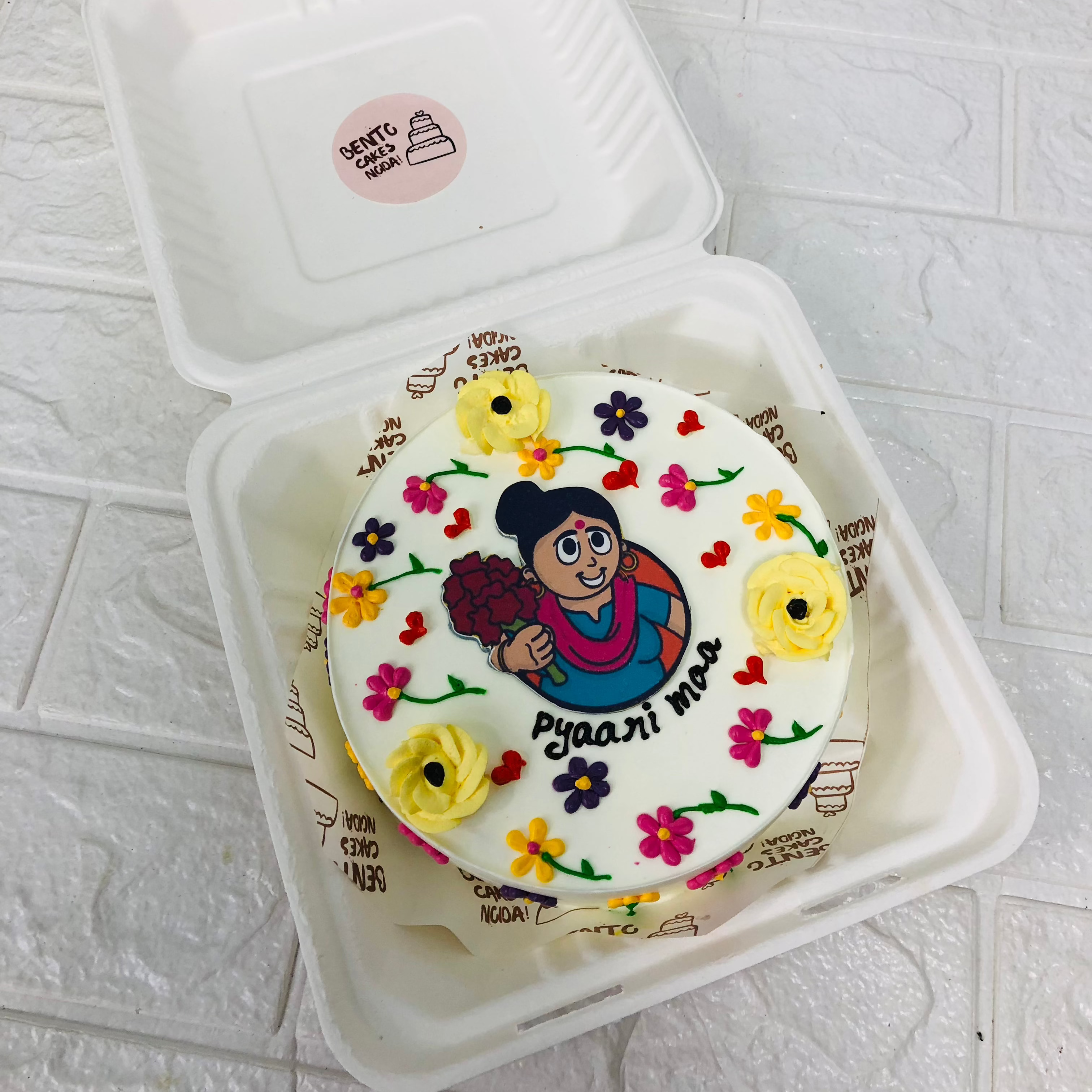 A colorful cake featuring a cheerful cartoon mother on top, perfect for mothers birthday celebration.
