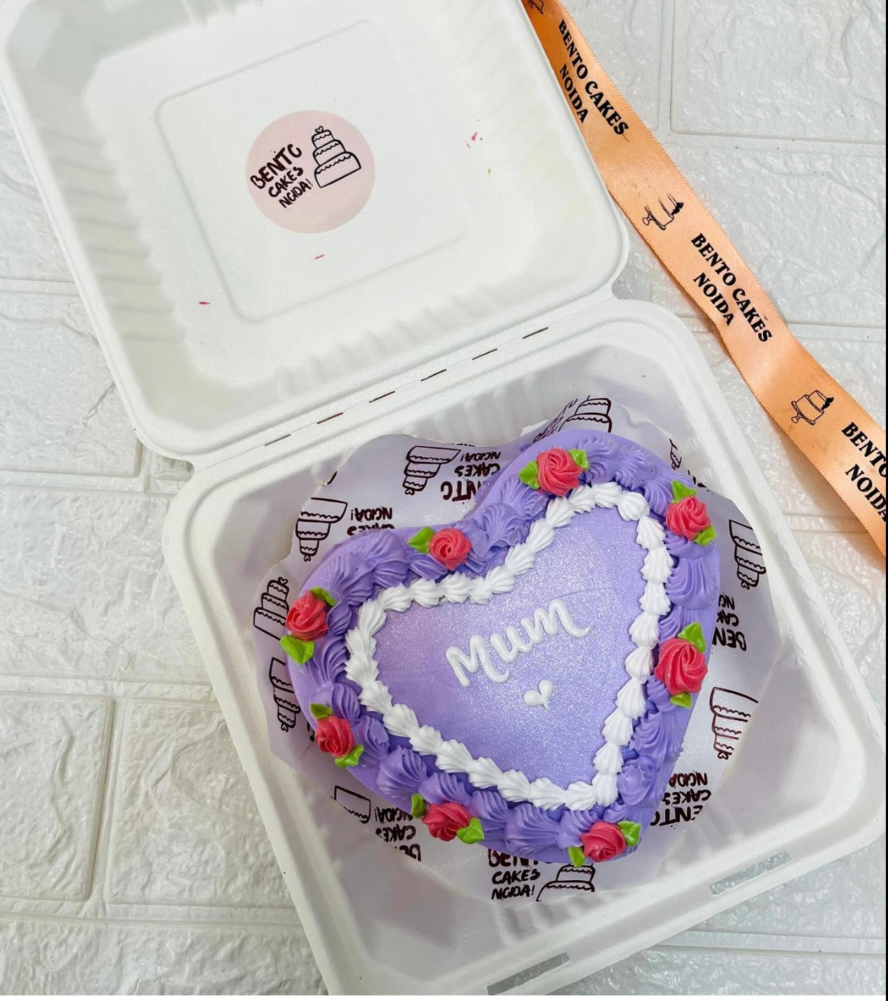 A light purple designer heart shape cake decorated for mothers day occasion and similar to it.