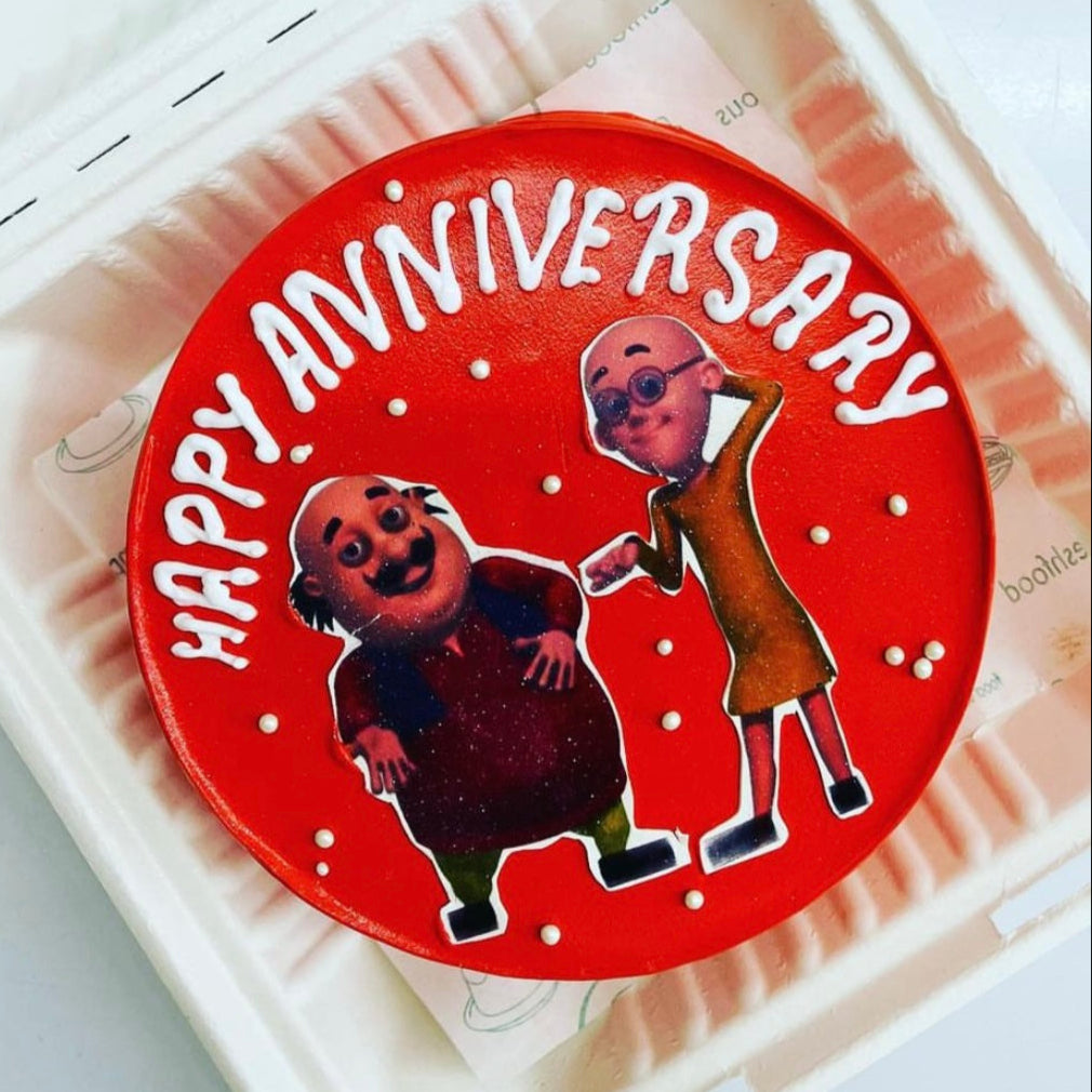 A gift box featuring a vibrant happy anniversary text and Motu Patlu Cartoon sticker, representing a special celebration.