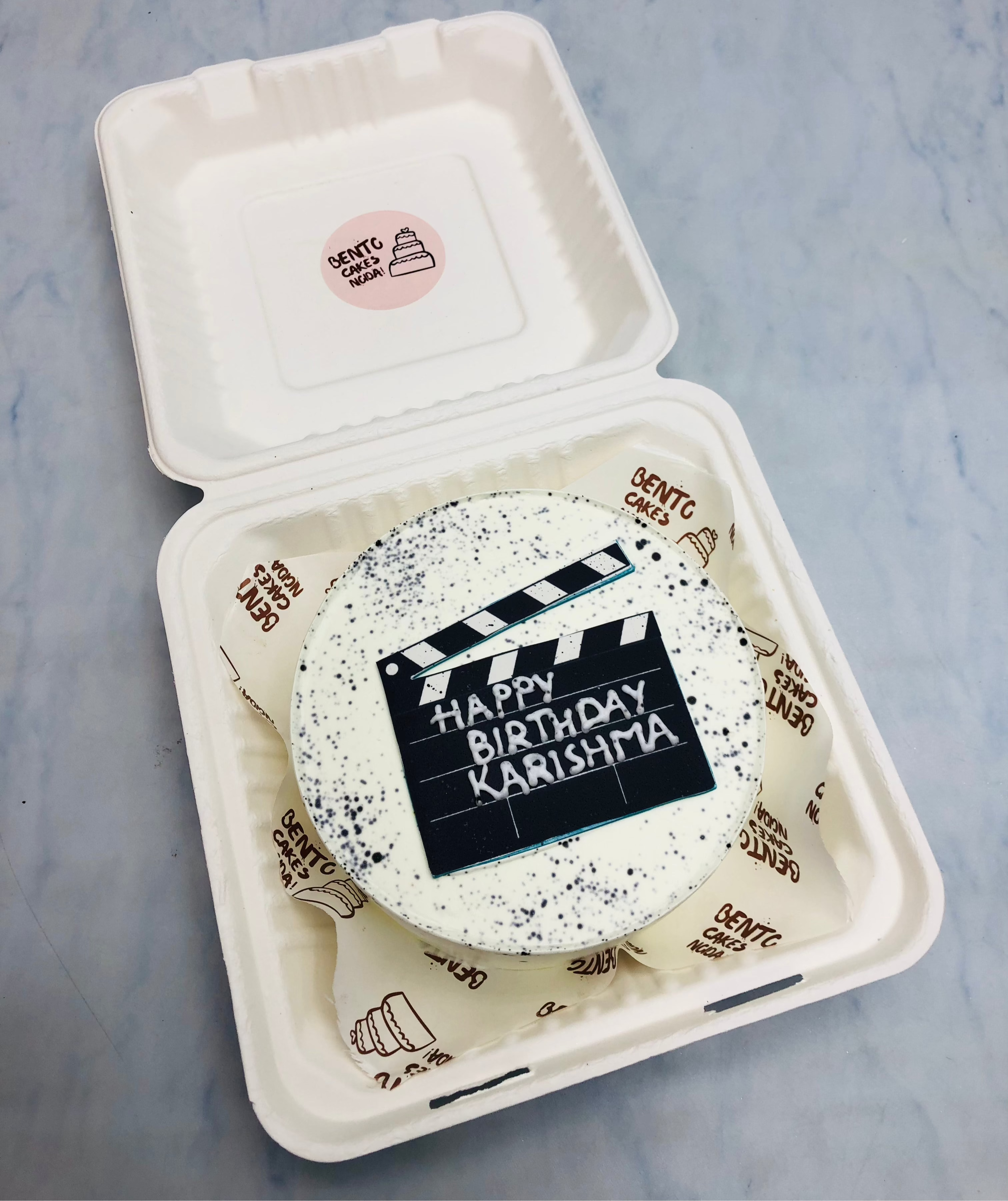 Aesthetic white bento cake is designed for movie director having a movie shooting takeout design.