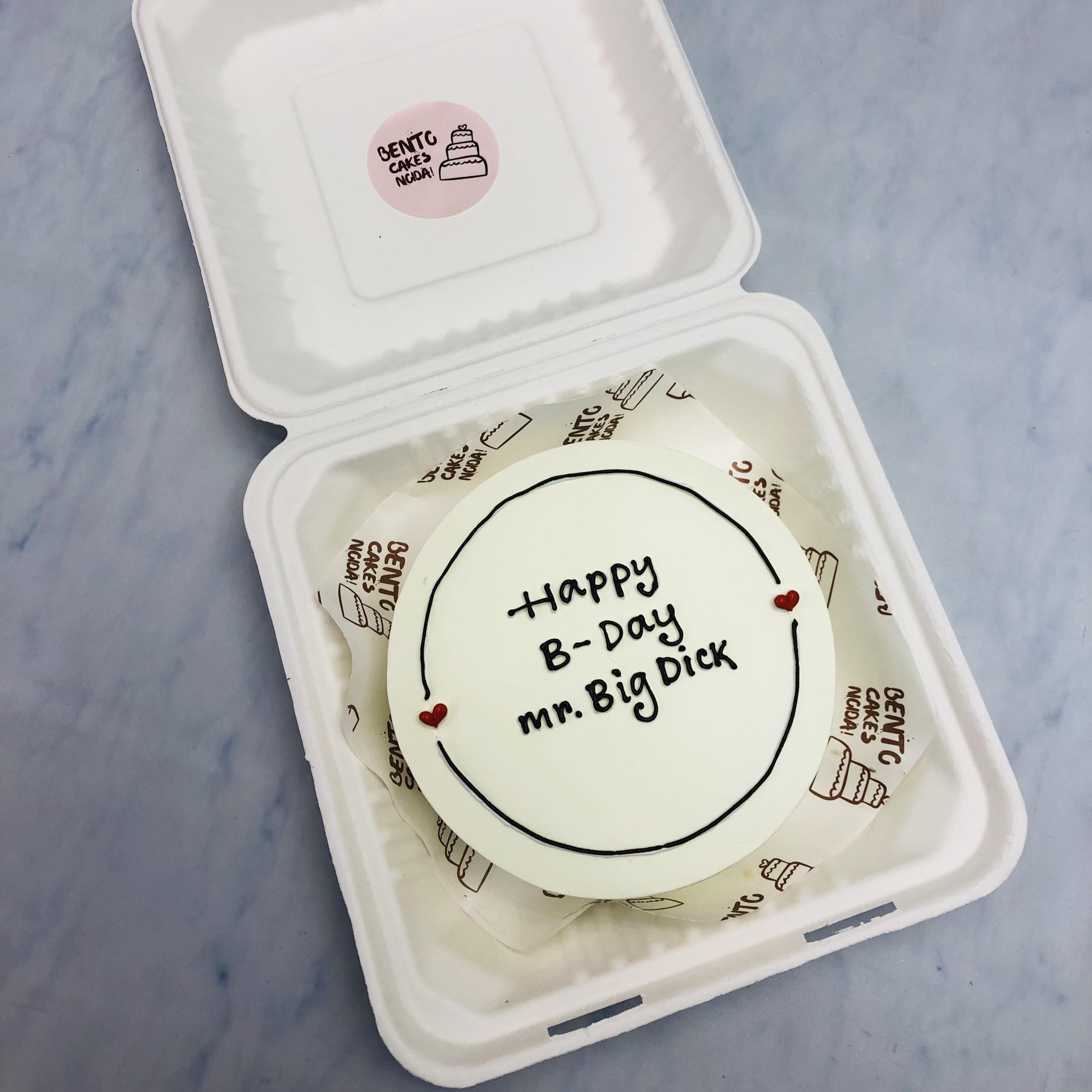 A basic white bento cake having bachelor text written in it.