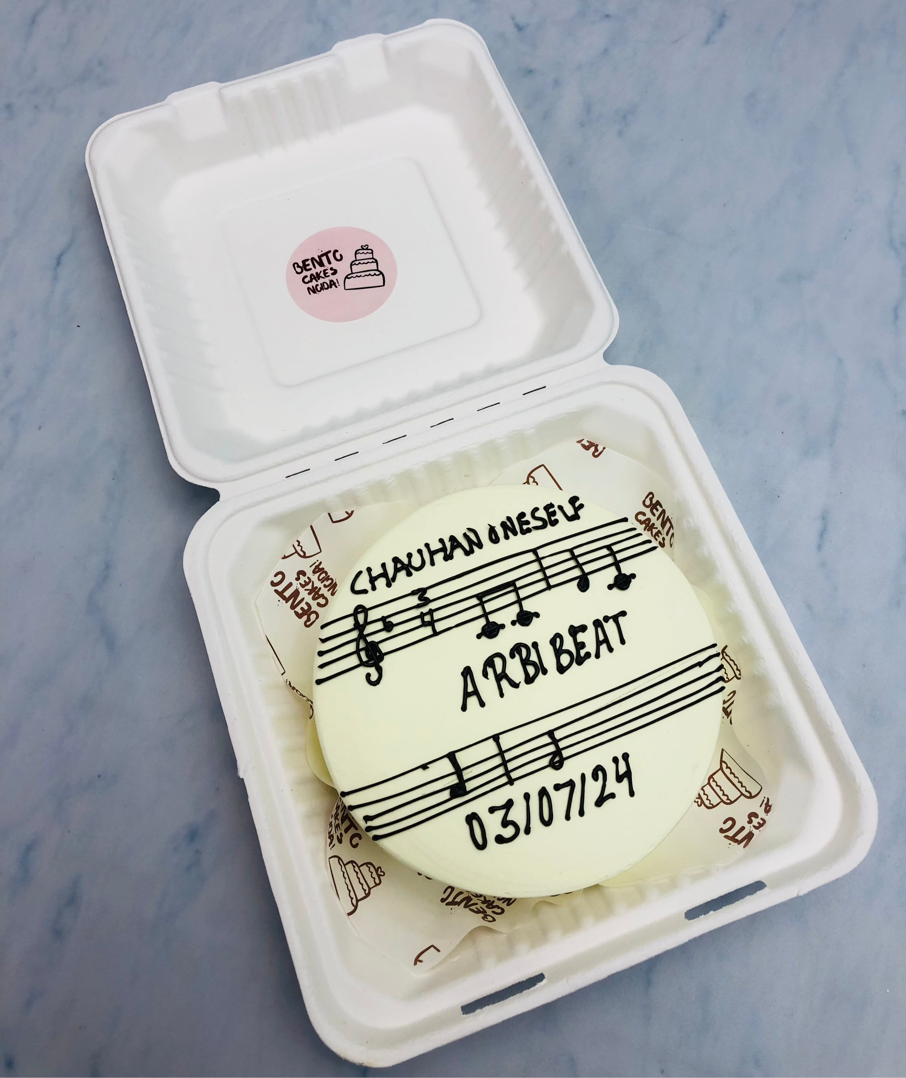 A white bento cake having music composers birthday theme.