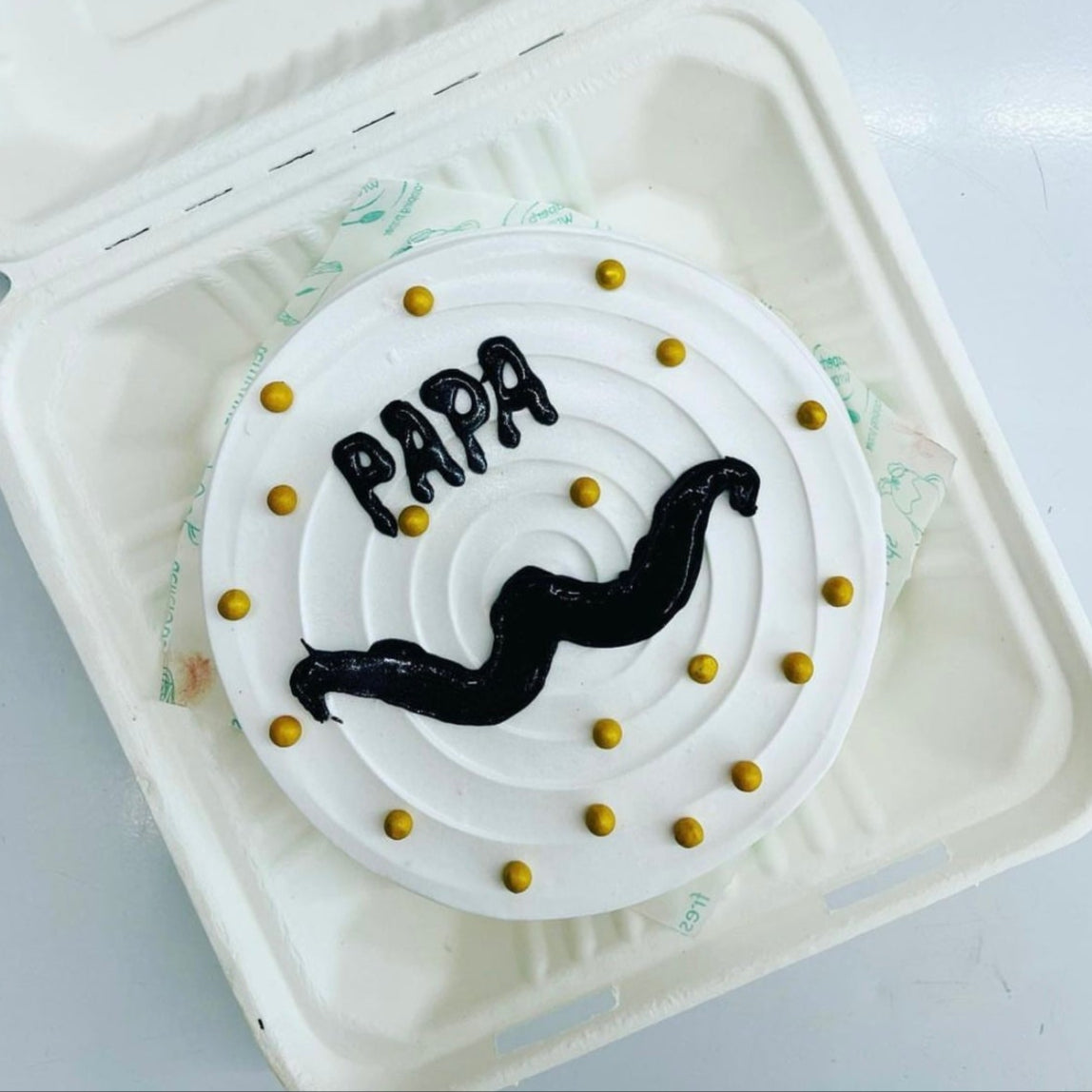 A playful cake adorned with a mustache and the word "papa," ideal for a birthday or Father's Day treat.