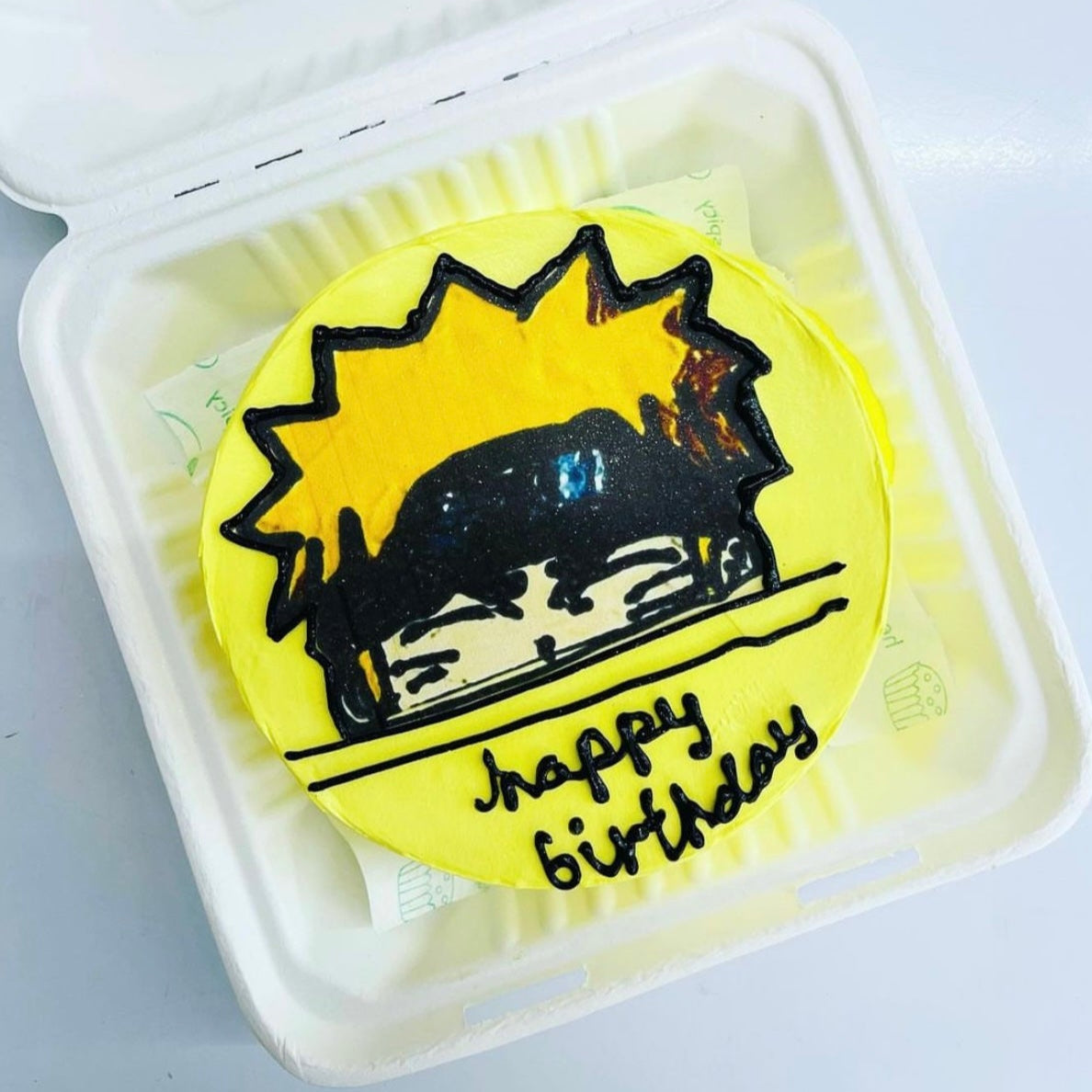 A delightful birthday cake displayed in a soft foamy container, showcasing a playful cartoon character, perfect for a party.