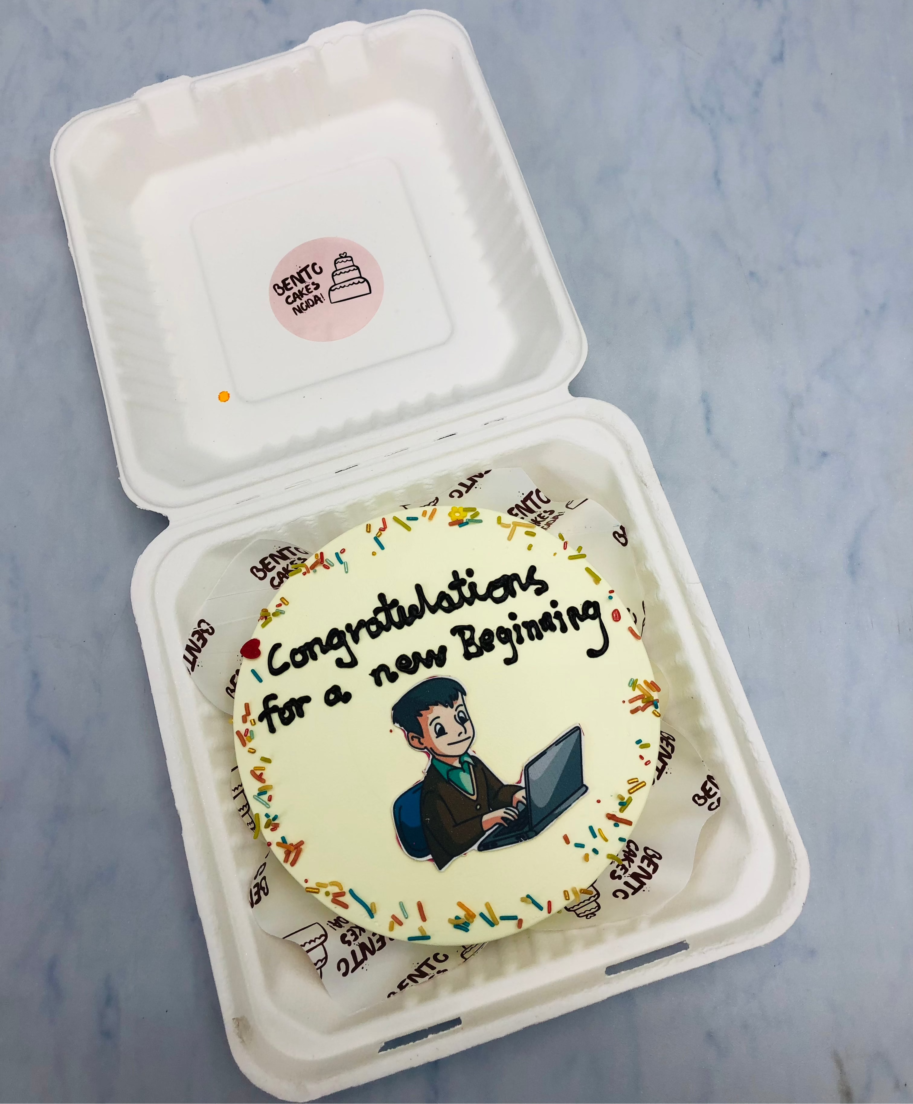 An offwhite bento cake is designed for a  man got new job and celebrating it.