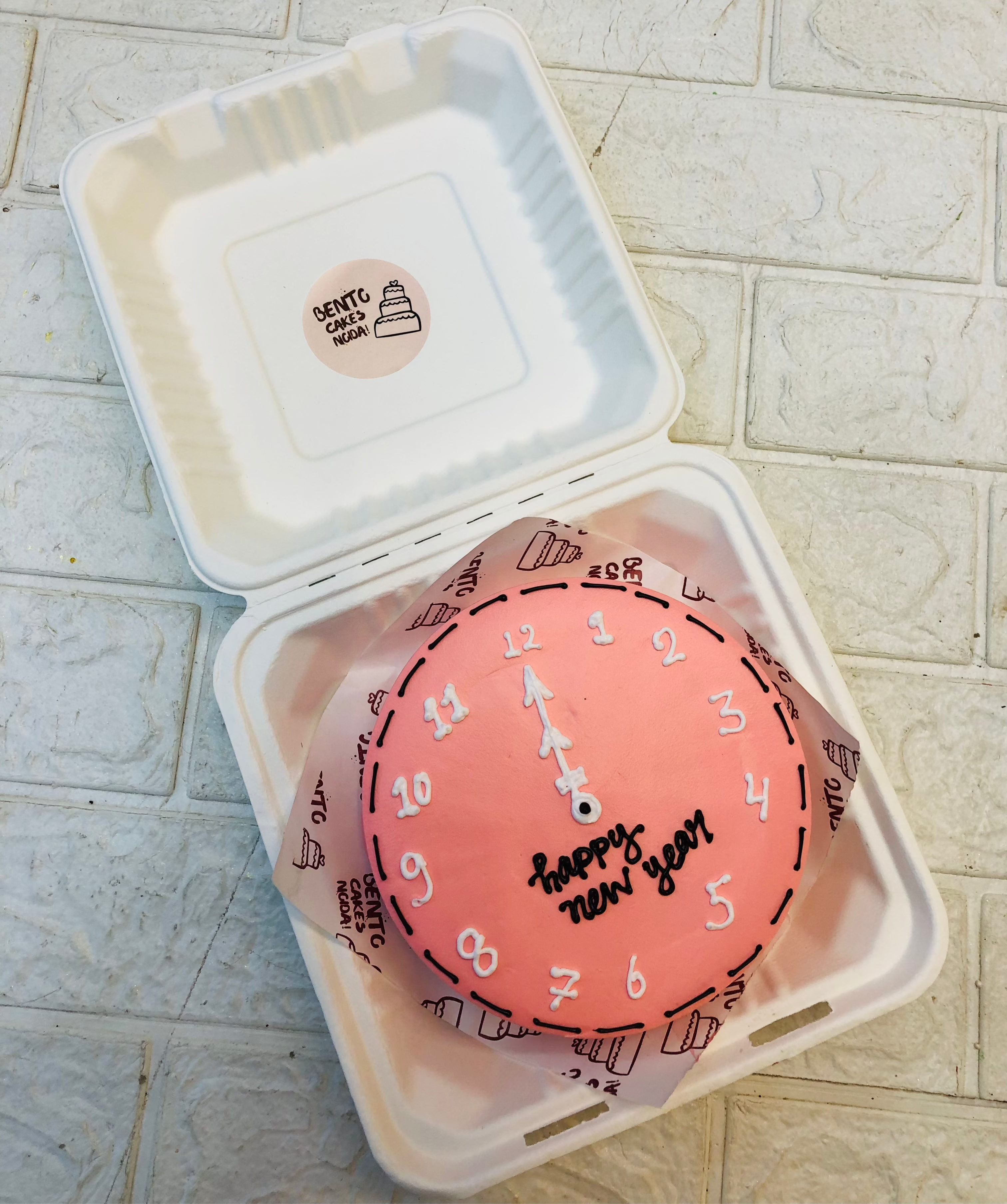 A rose gold bento cake having a clock design for new year countdown.