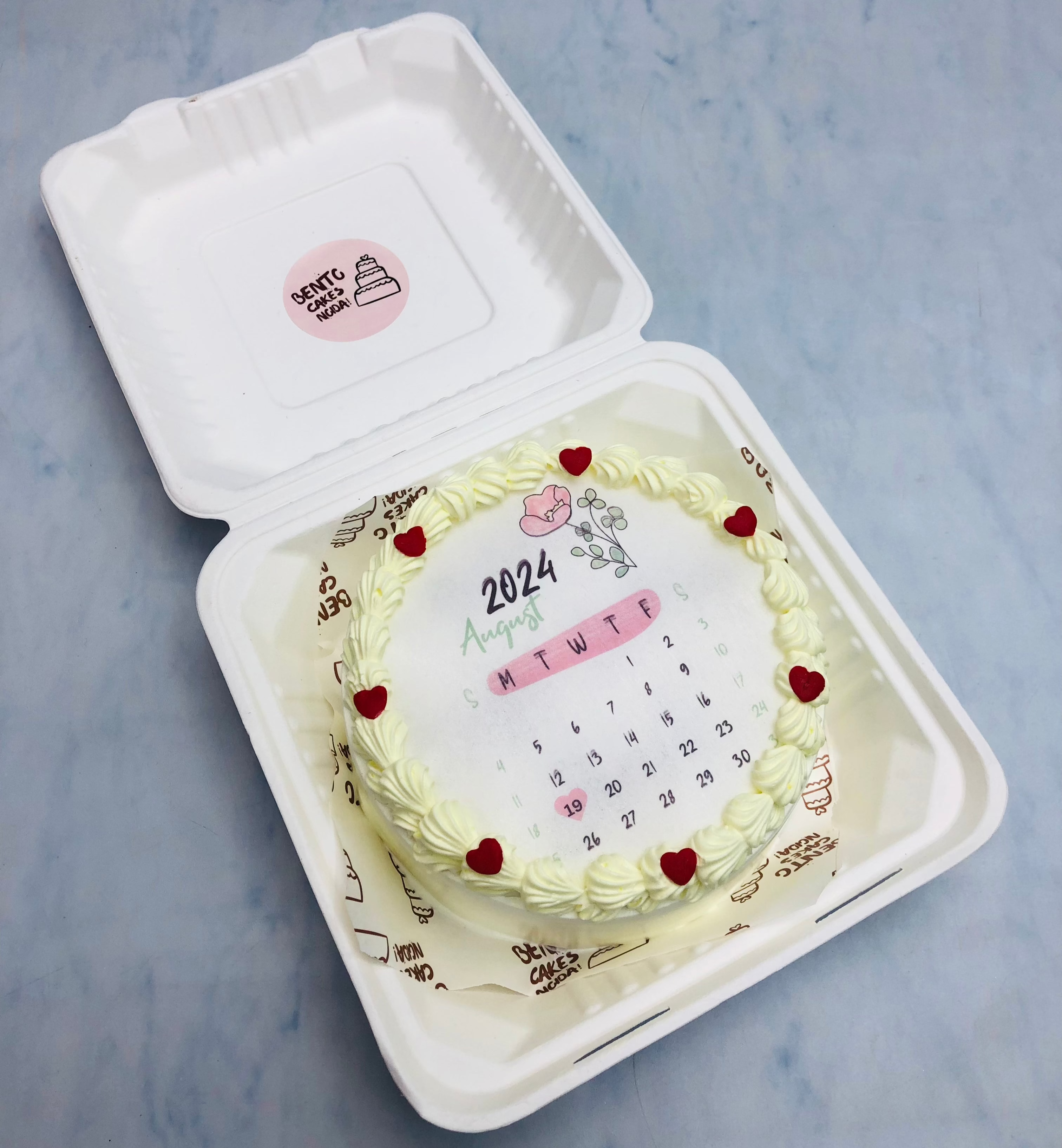 A white fire bento cake having Agust month calendar design in it.