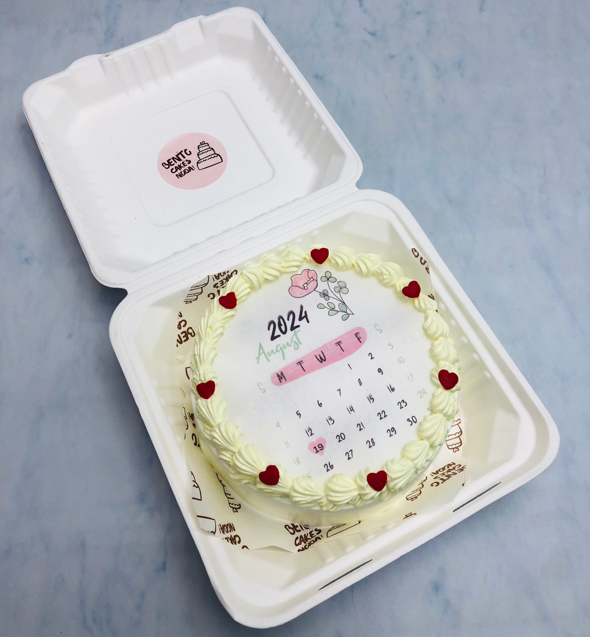A white fire bento cake having Agust month calendar design in it.