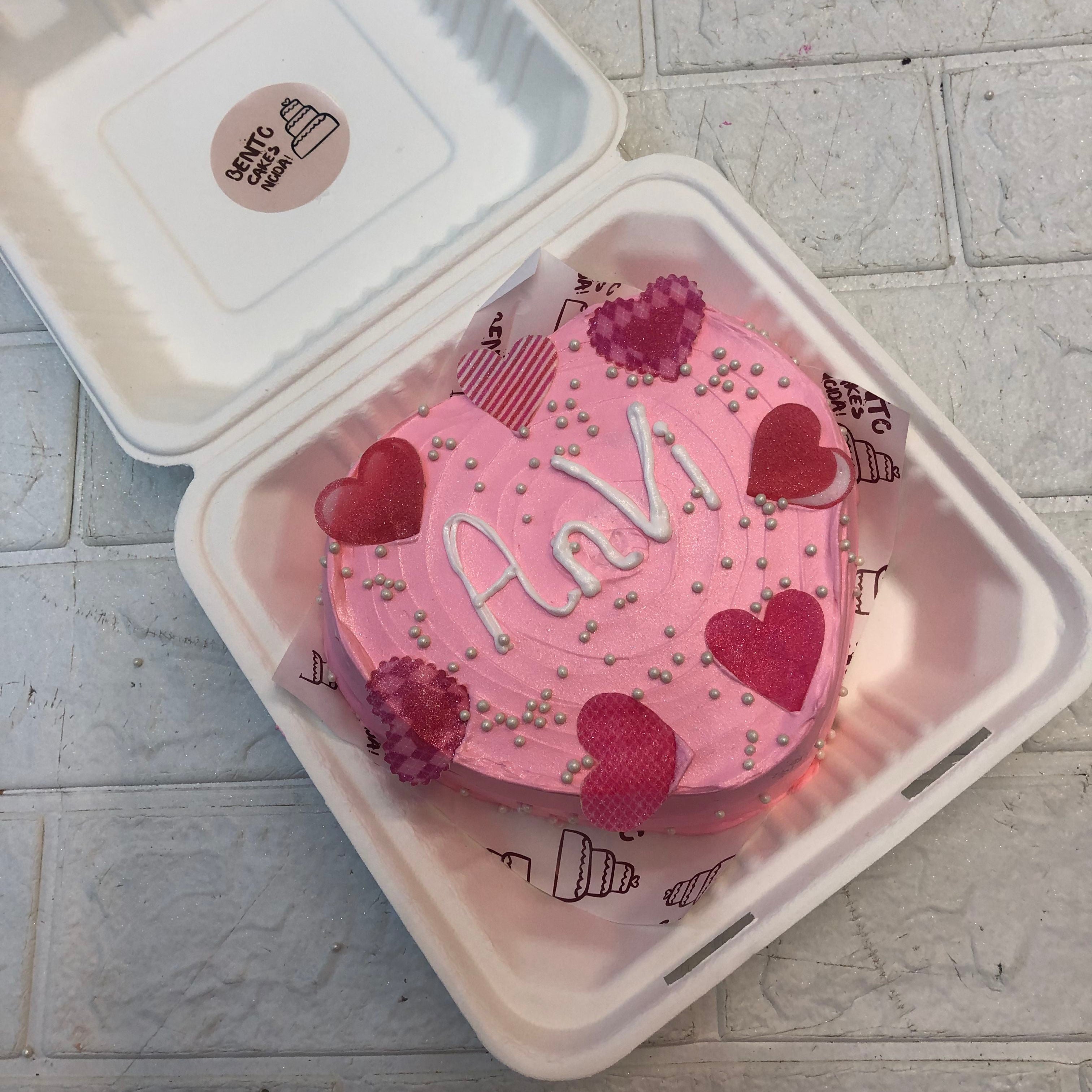 A Pearl Pink Heart Bento Cake with designer hearts cutting with silver sprikles on it.