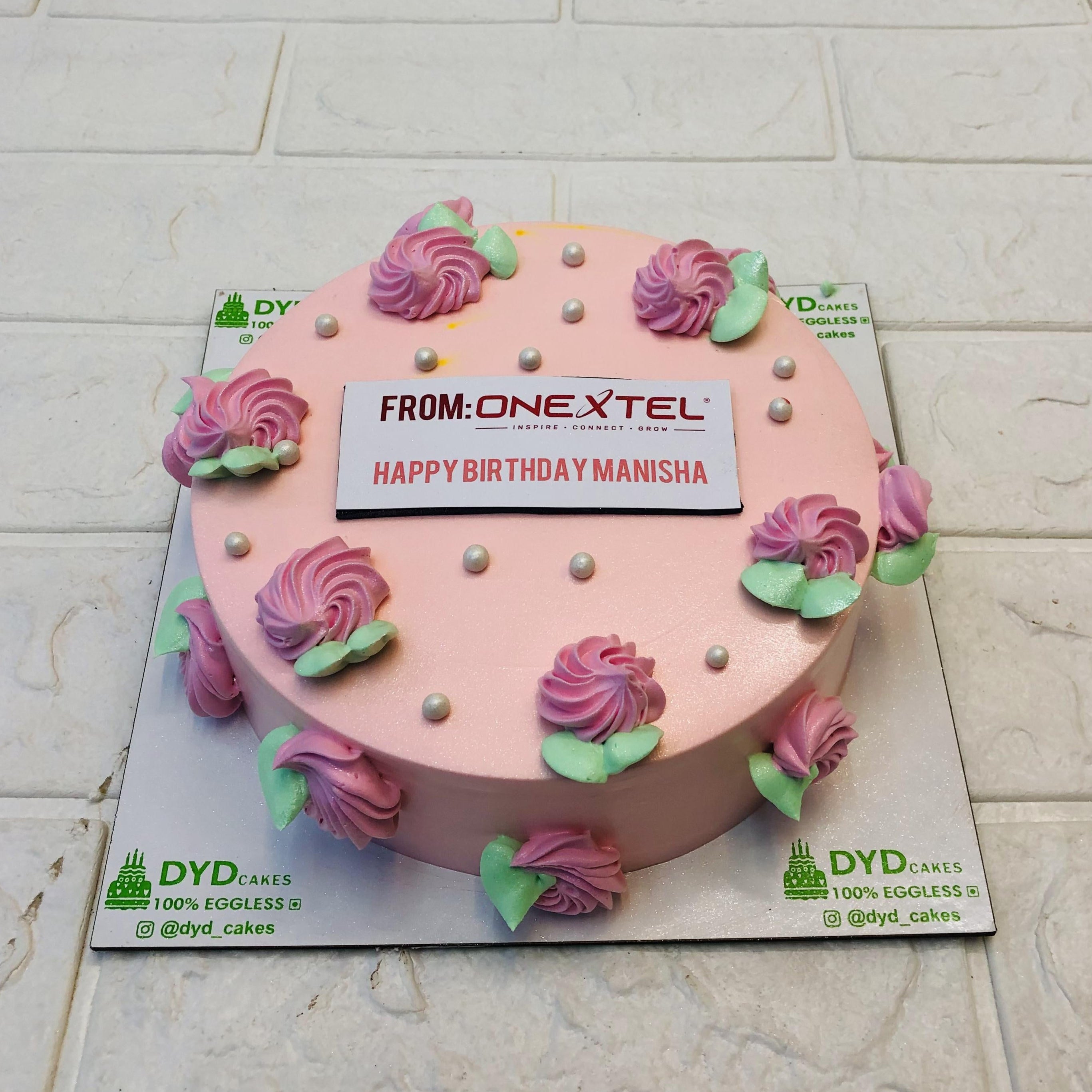 A pach color cake with pink florals design with green leaves made for commercial birthday celebration.