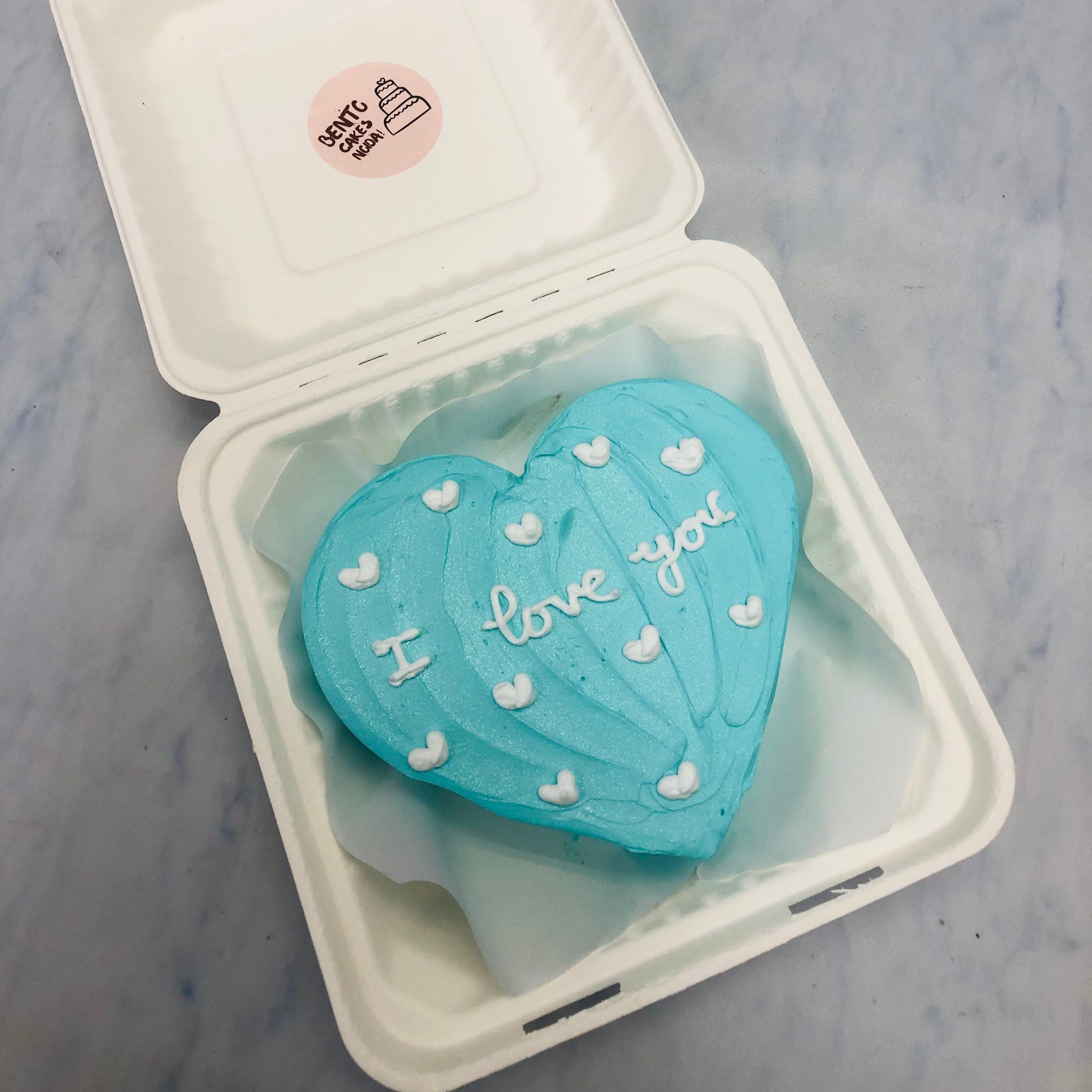 A cool blue heart shape cake with wavy design and filled with white litte hearts all over the cake.