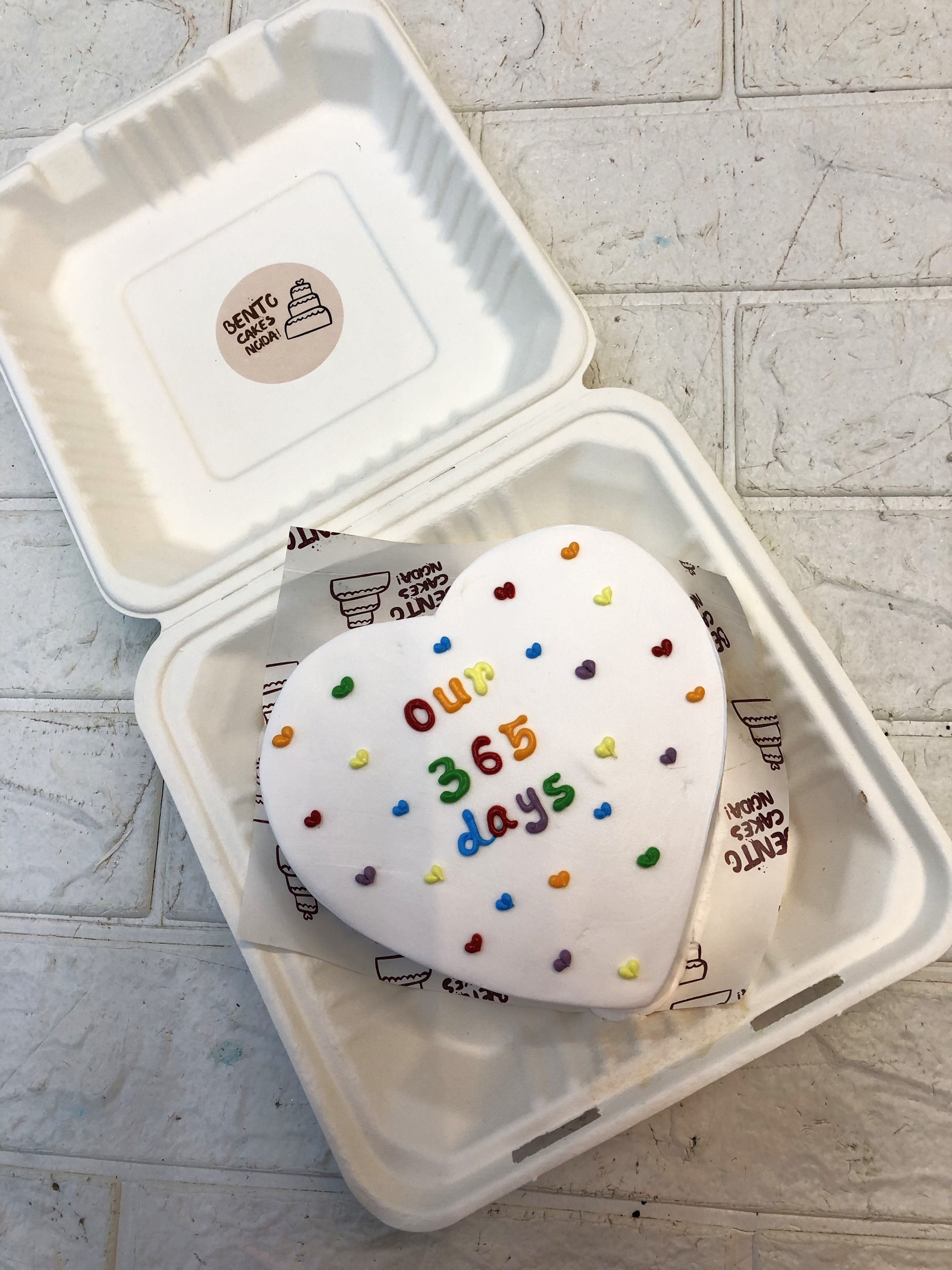 A white heart shape cake filled with colorful little hearts design.