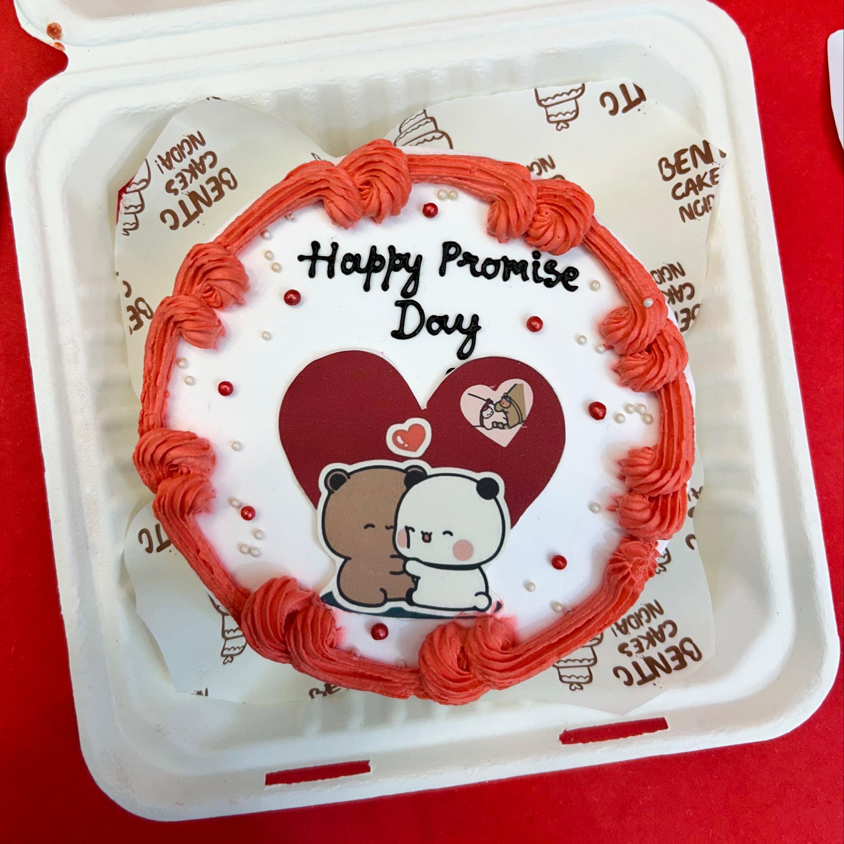 Promise Day cake with a round design in a bento box with front view, accompanied by the Bubu Dudu cartoon character.