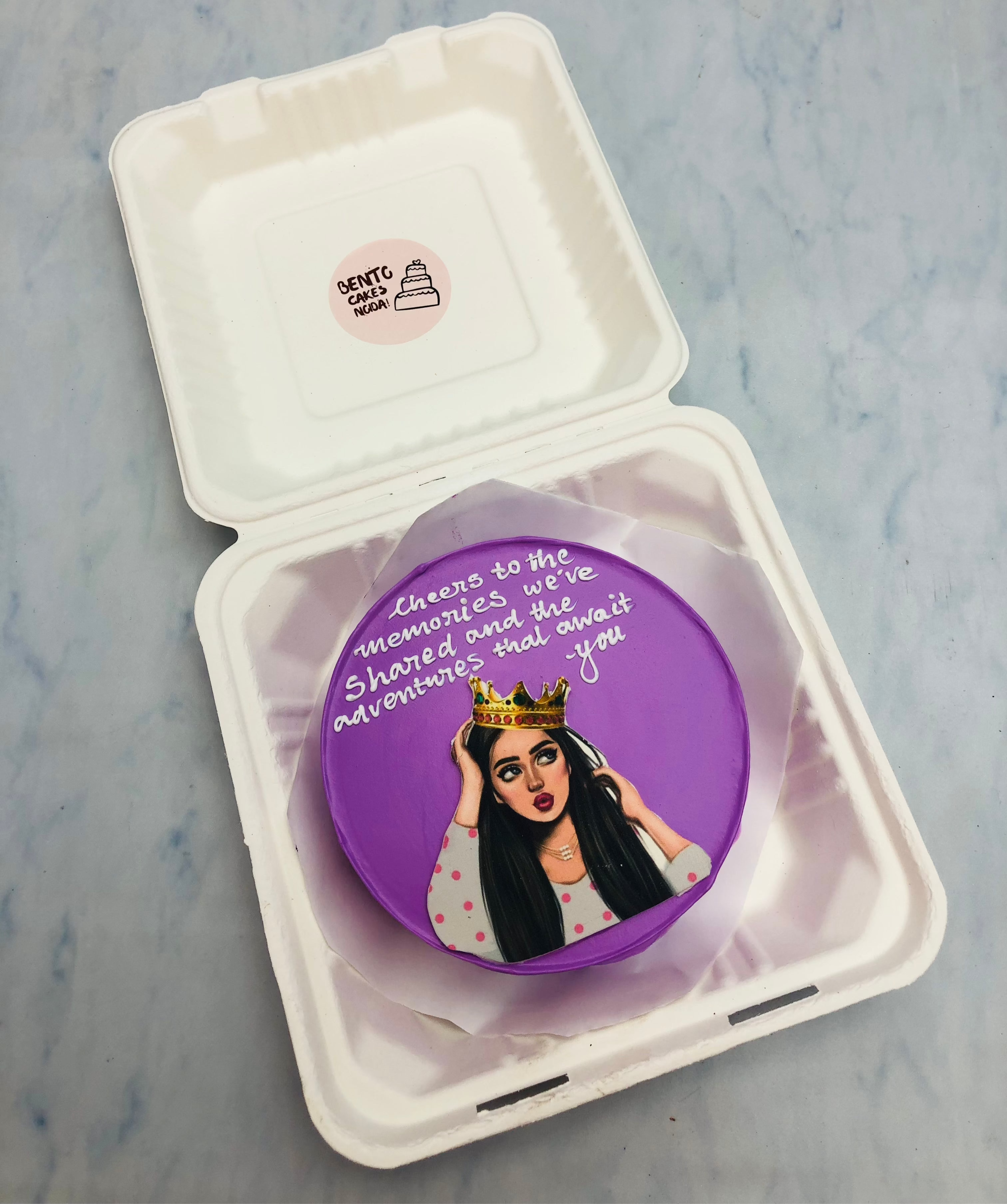 A purple bento cake with a queen girls print with custom message.