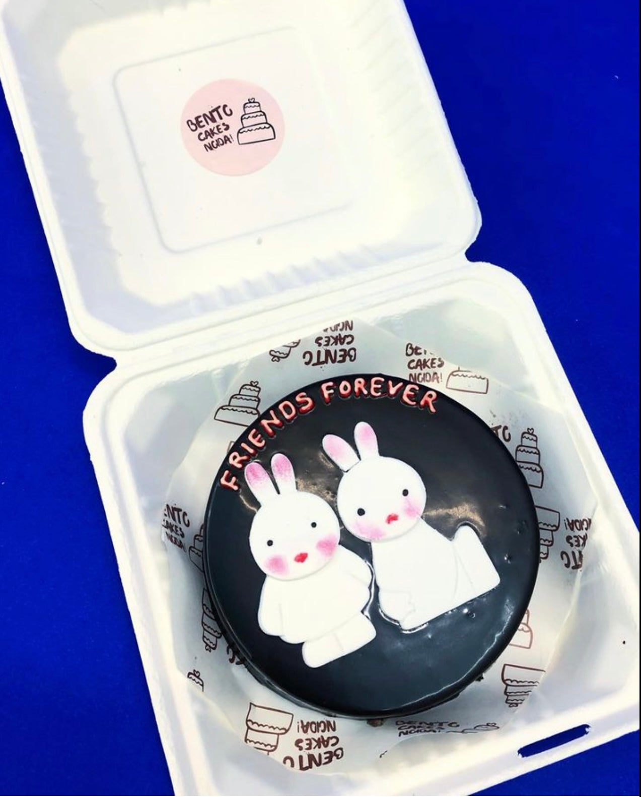 A chocolety black bento cake showing two rabbit friends design .