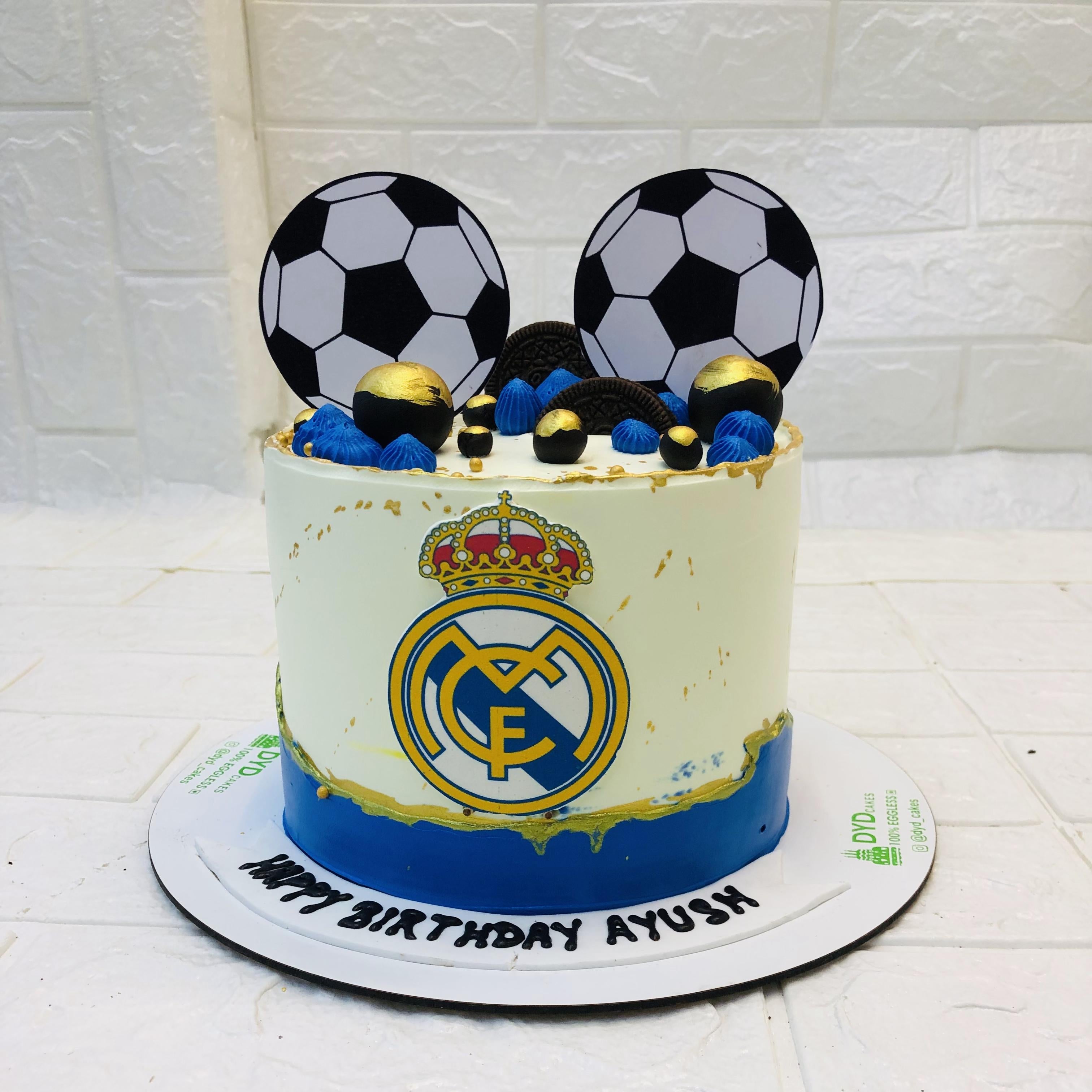 A whimsical cake featuring a soccer ball design and a crown head on top, perfect for a themed celebration.