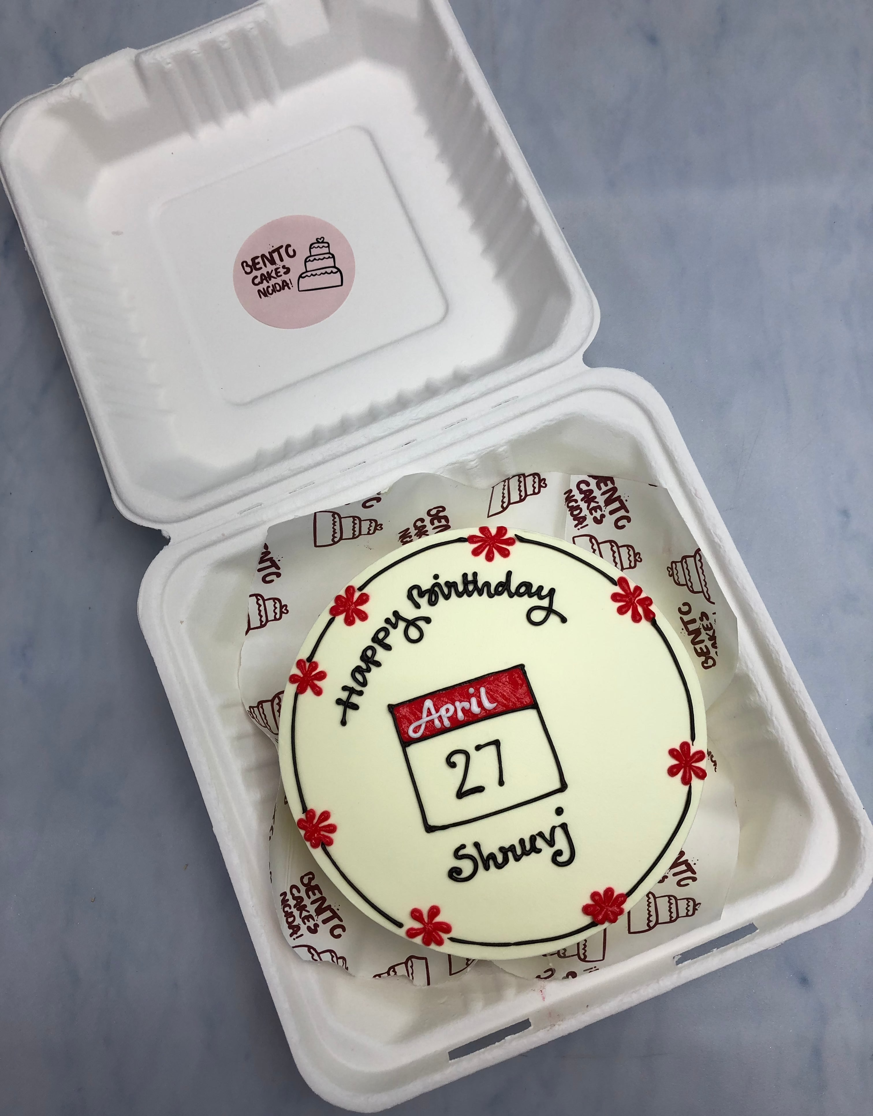 An offwhite floral design calendar theme bento cake for birthday.