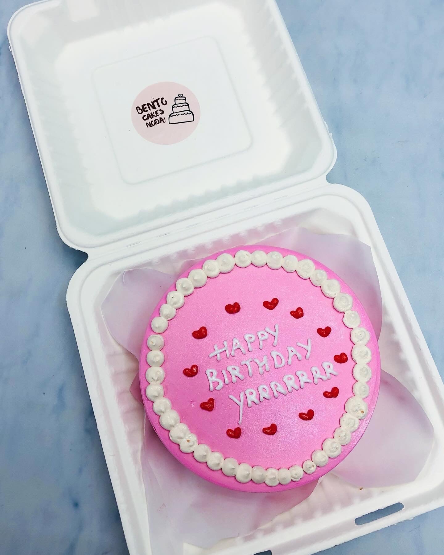 A pretty pink bento cake with a friends birthday text.