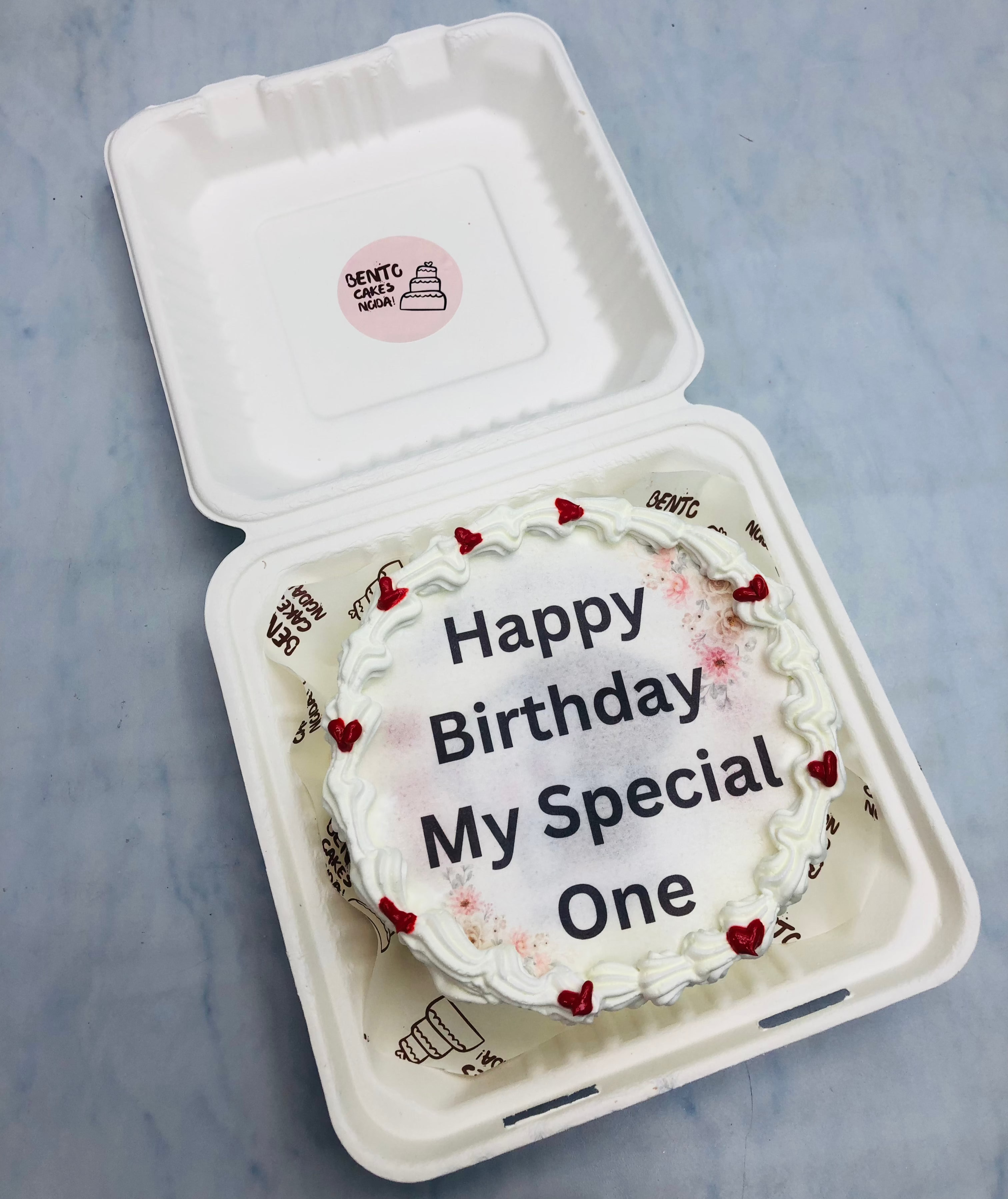 A white fire bento cake with a special text written on fire paper.