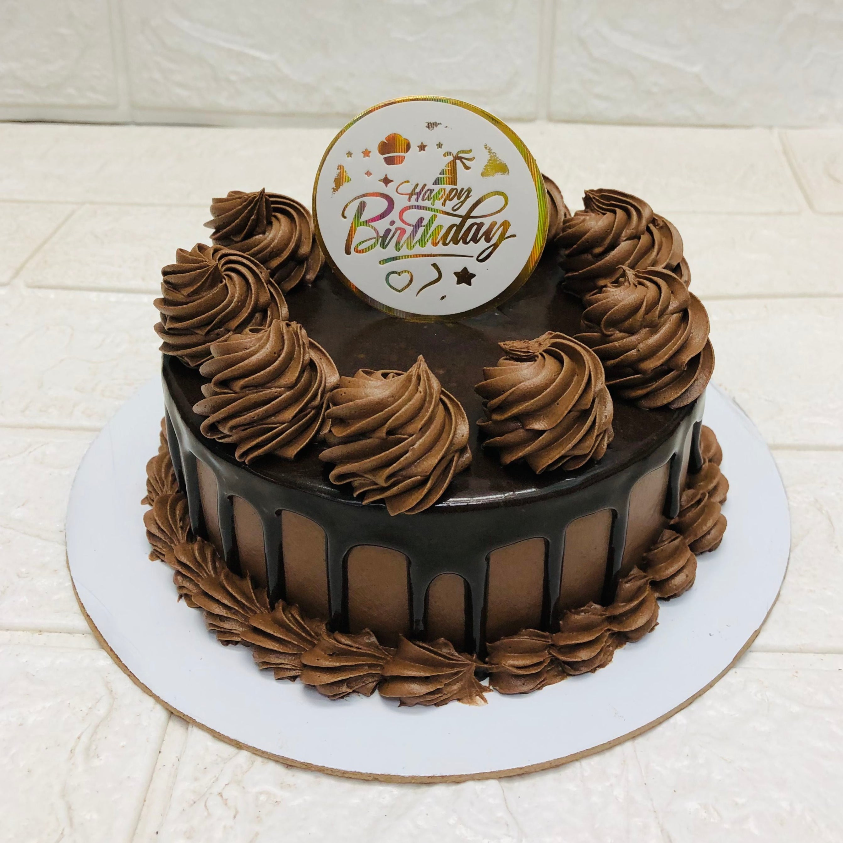 A rich chocolate cake featuring a cheerful "Happy Birthday" sign, ideal for a festive birthday celebration.