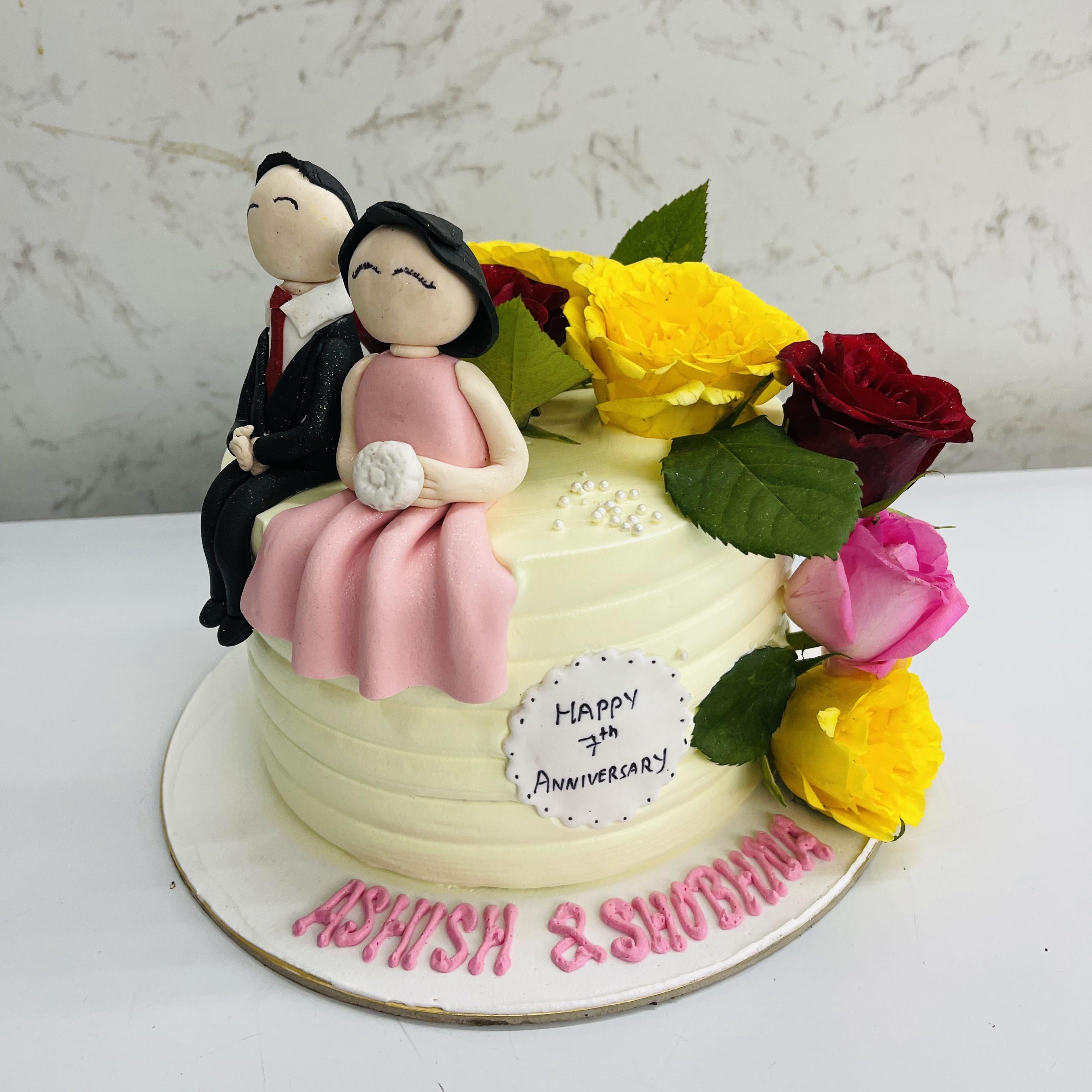 A romantic couples mineature cake with colorfu rosed  for 7th anniversary celebraton.