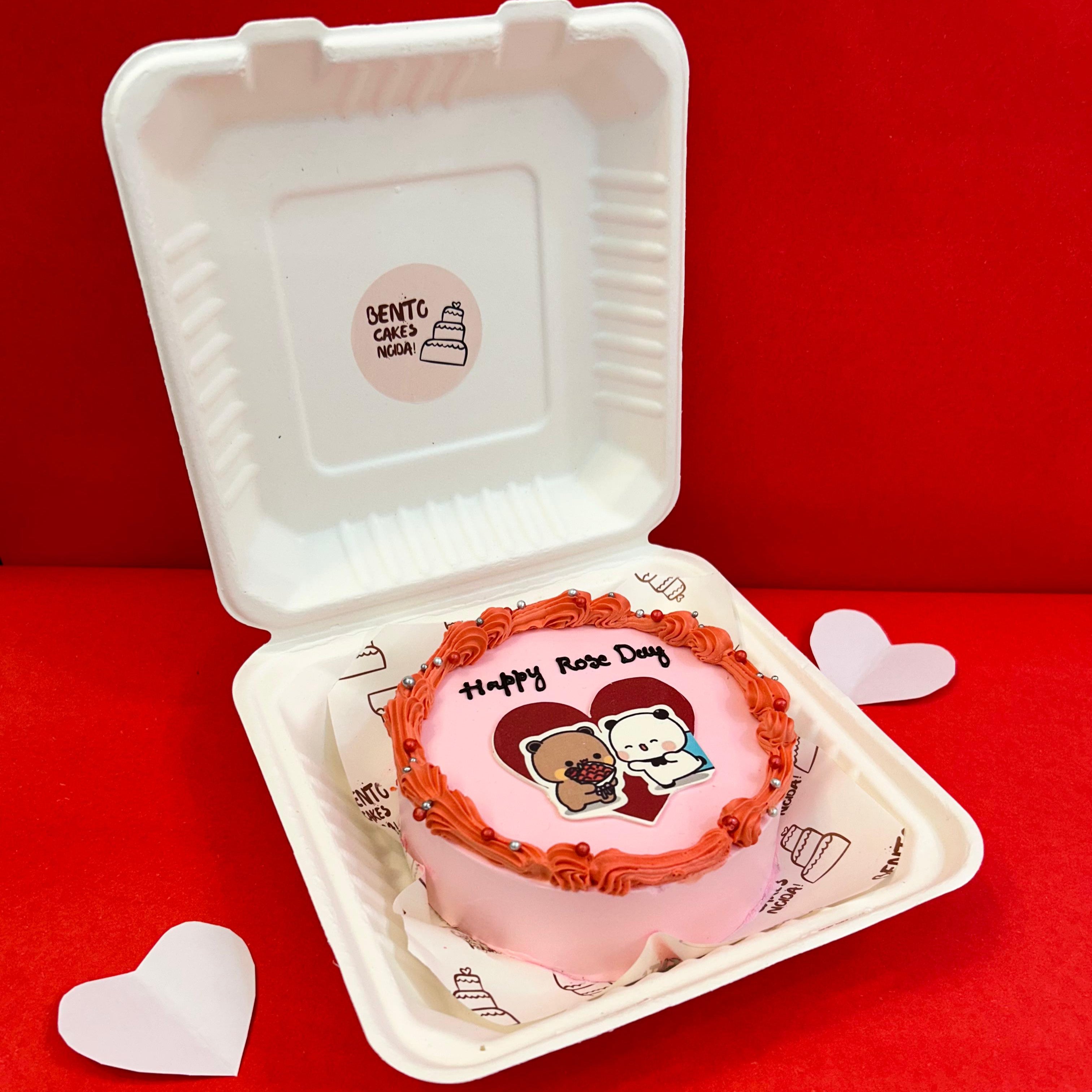 A delightful cake with a heart design, accompanied by the Bubu Dudu cartoon character from side view, ideal for Rose Day festivities.