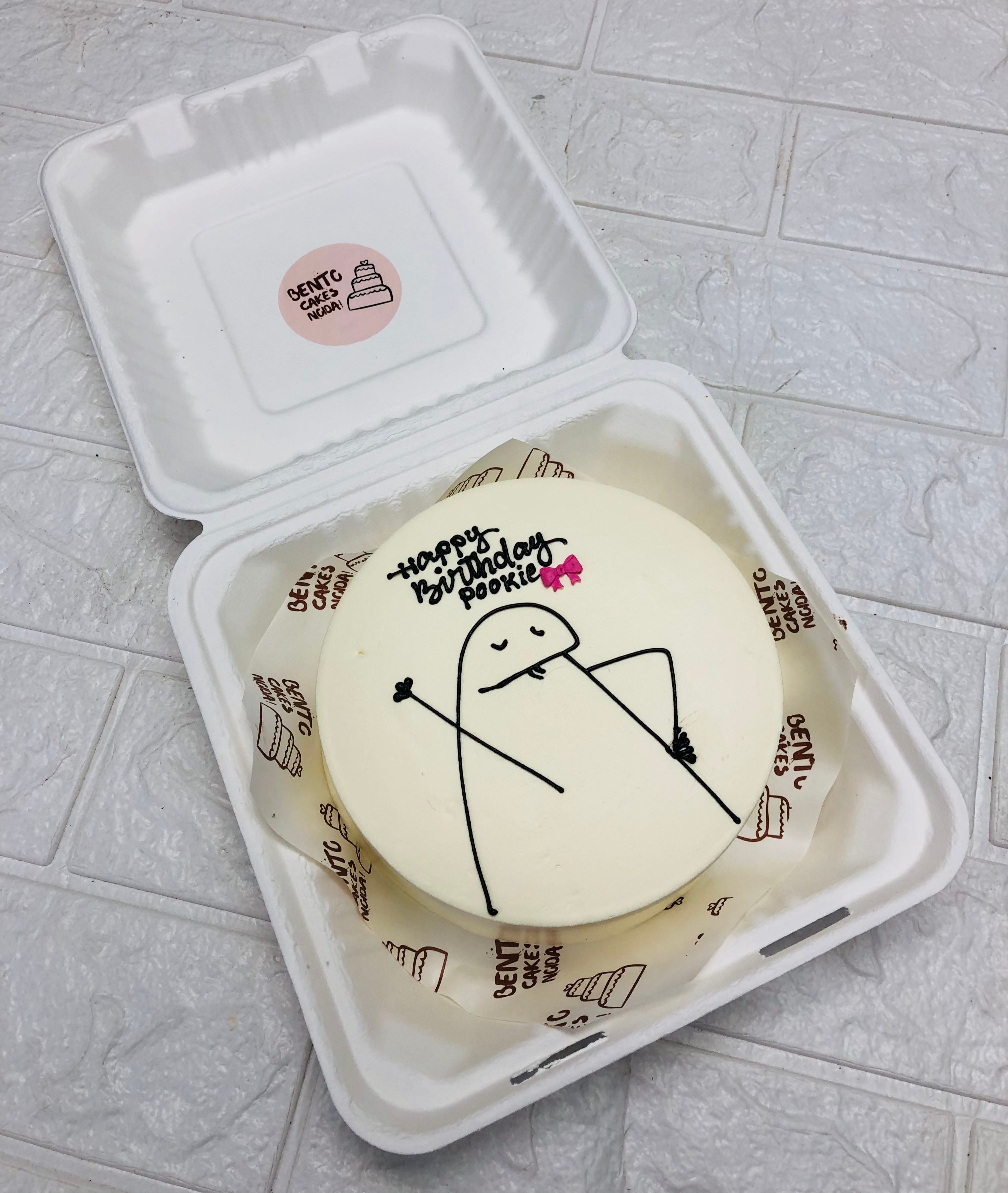 An off white bento cake having a mimi carton character in sad mood on her birthday.