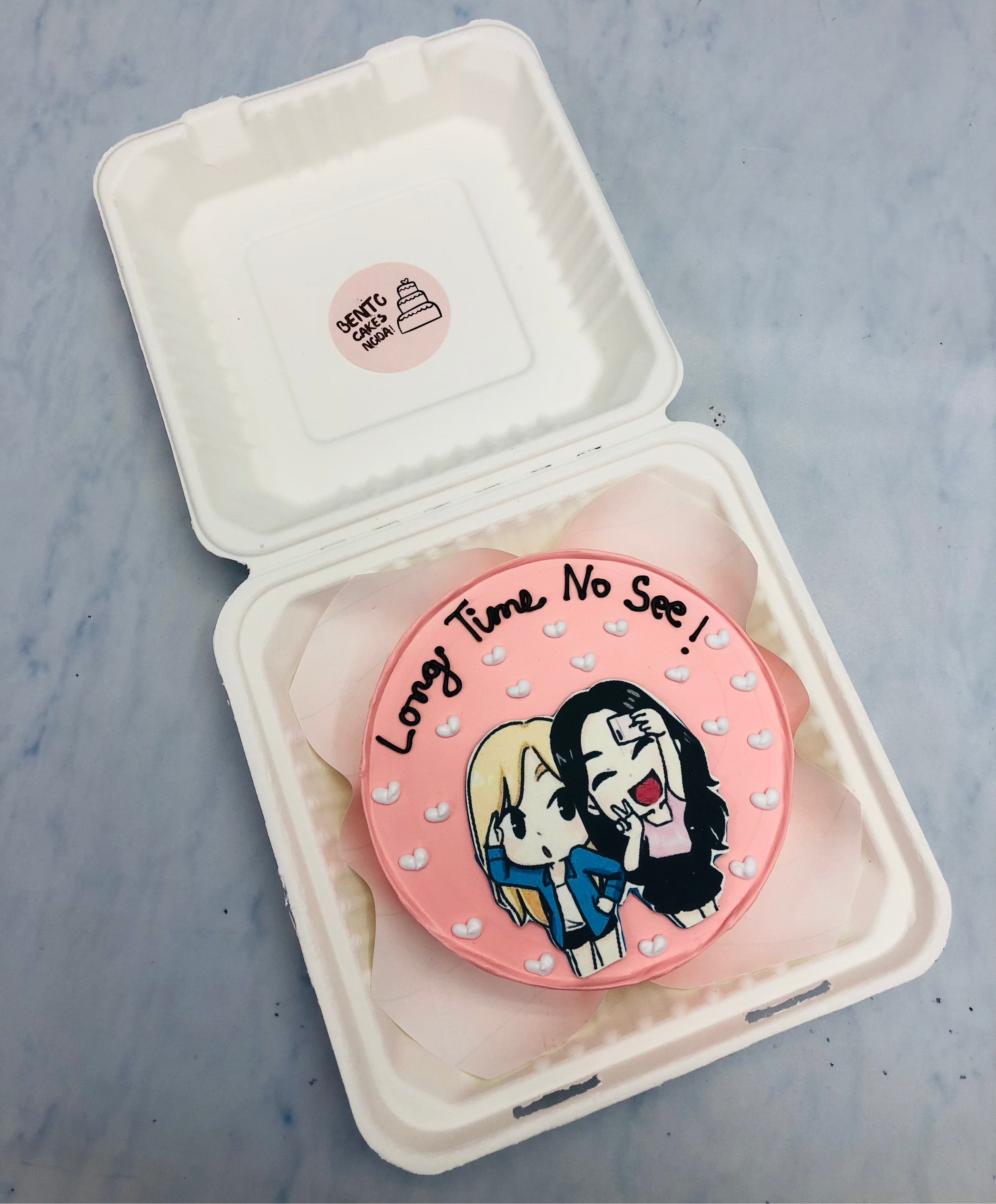 A rose gold bento cake designed with 2 friends taking selfie after log time visit.