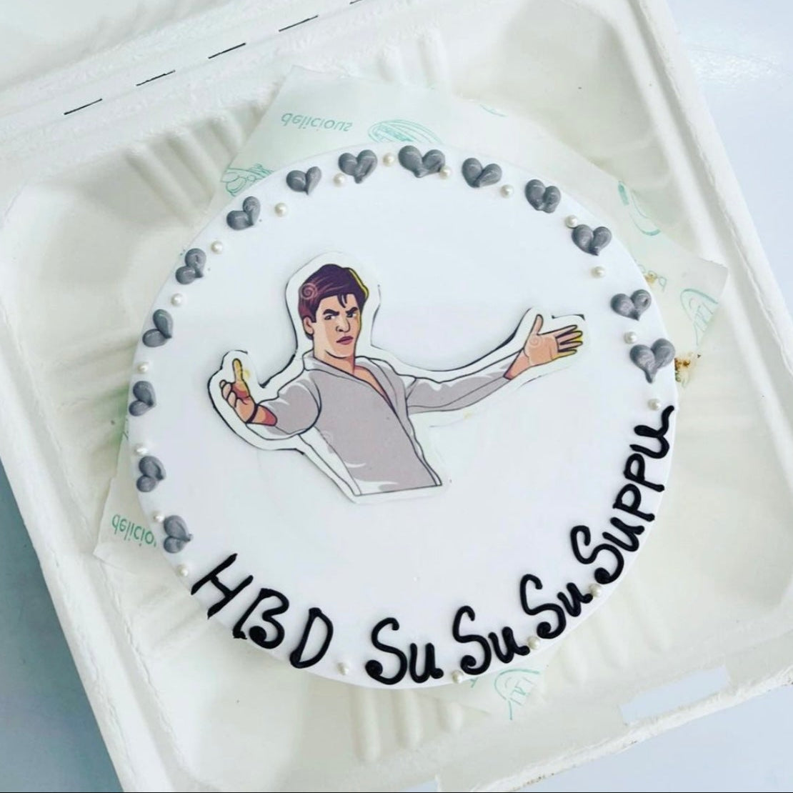 A cake in a box featuring a picture of  smiling Shahrukh Khan on top, ready for a special celebration.