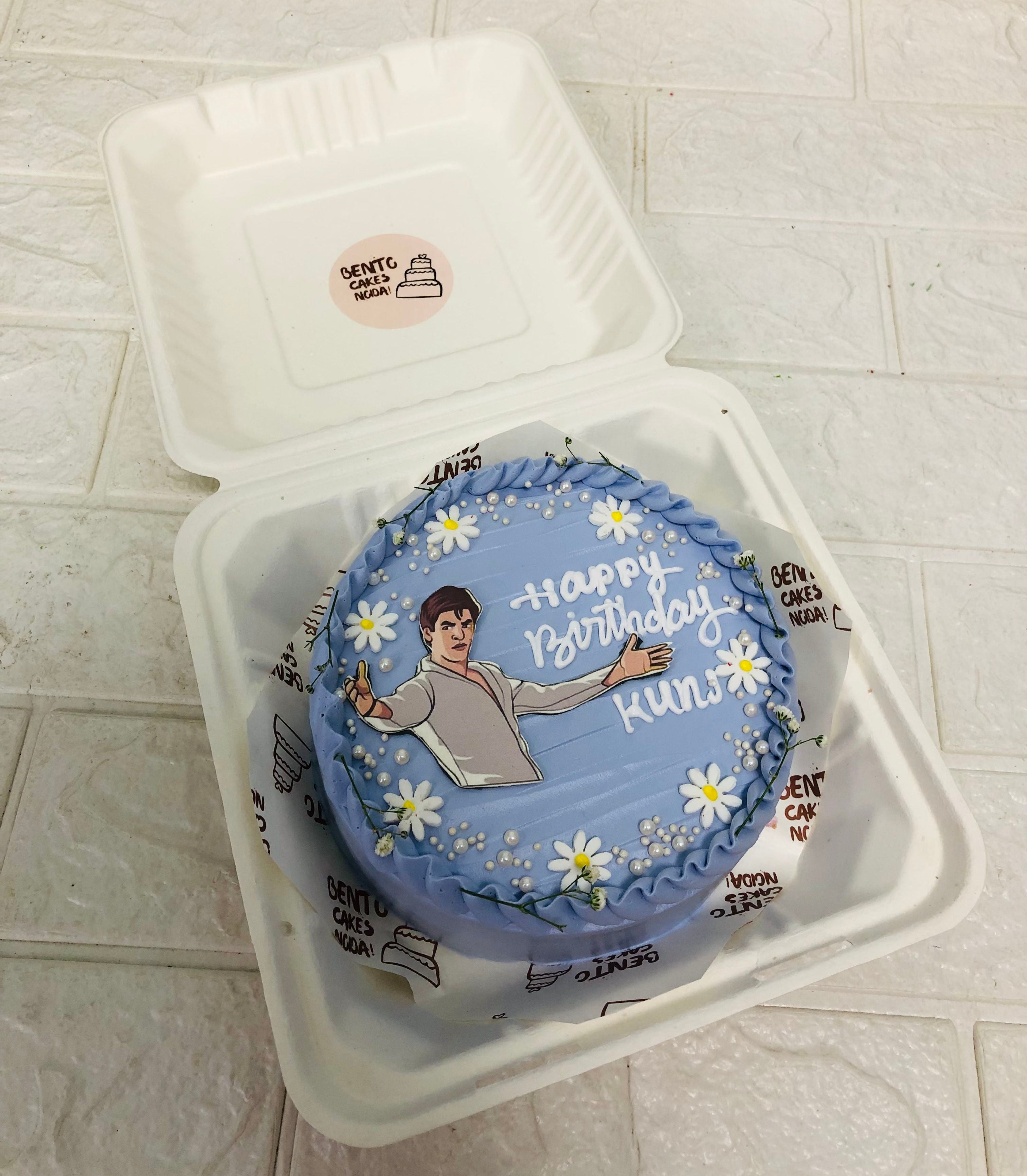 A blue bento cake is designed for sharukh khan fan's bierhday with floral touch.